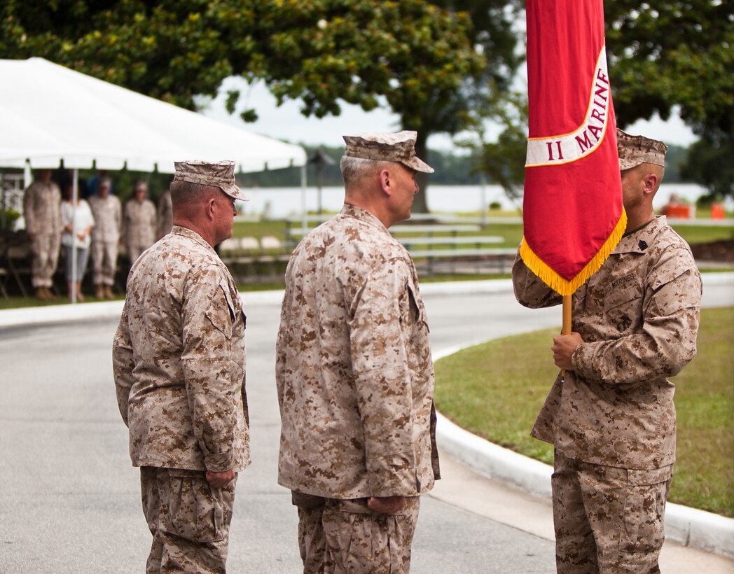 Sgt. Maj. Robert G. VanOostrom, senior enlisted Marine for II Marine Expeditionary Force, delivers the II MEF unit colors to Lt. Gen. John M. Paxton Jr. (center), who will pass the colors to Maj. Gen. Raymond C. Fox (left), representing the transfer of command, during the II MEF change of command ceremony aboard Camp Lejeune, N.C., July 13.