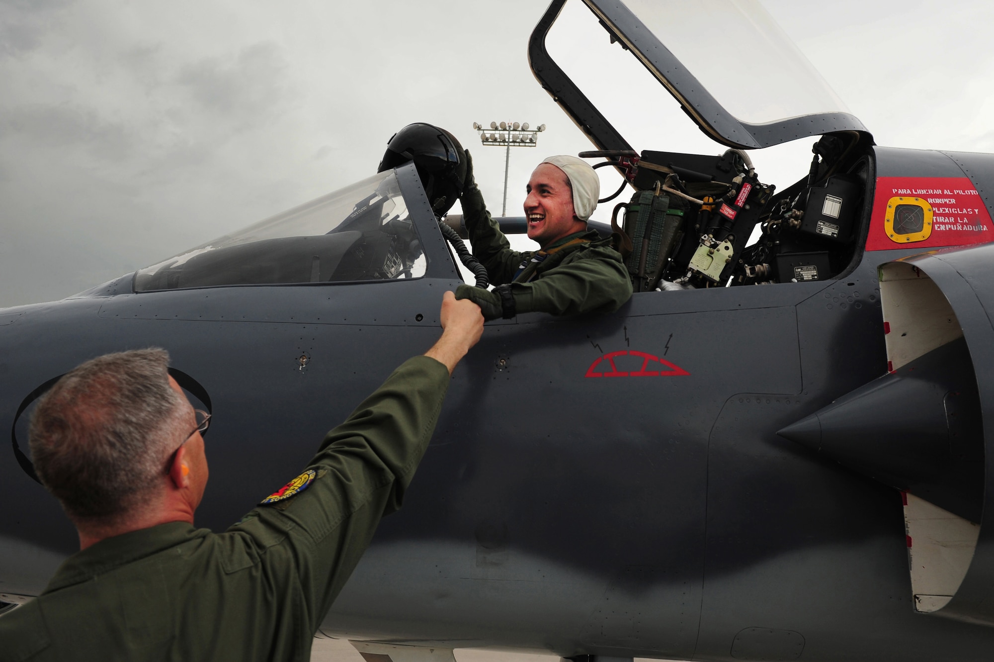 U.S. Air Force Col. Hans Palaoro, Chief, United States Air Force Mission-Colombia, shakes the hand of Colombian Air Force Capt. Freddy Figueroa, pilot, after landing at Nellis Air Force Base, Nev., July 13, 2012. Palaoro welcomes the Colombian Air Force on their arrival at Nellis for Colombia's first-ever RED FLAG. Their arrival culminates two years of preparation and training for this long-awaited event which begins Monday. (U.S. Air Force photo by Staff Sgt. William P. Coleman)