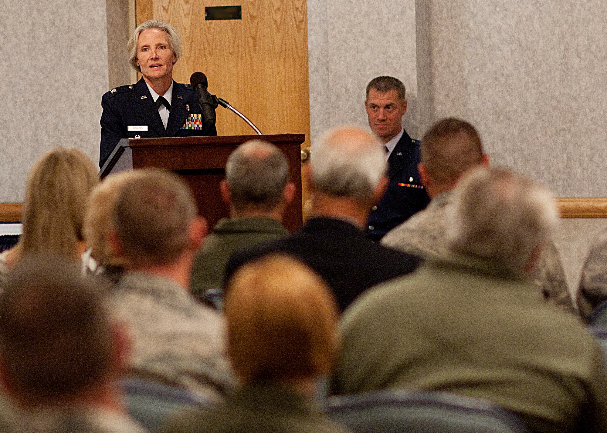 Col. Bridget Gregory, 90th Medical Group commander, speaks to the attendees of the 90th MDG change-of-command ceremony July 10. Gregory assumed command from Col. Francesca Vasta-Falldorf. (U.S. Air Force photo illustration by Airman 1st Class Jason Wiese. U.S. Air Force photo by Matt Bilden)