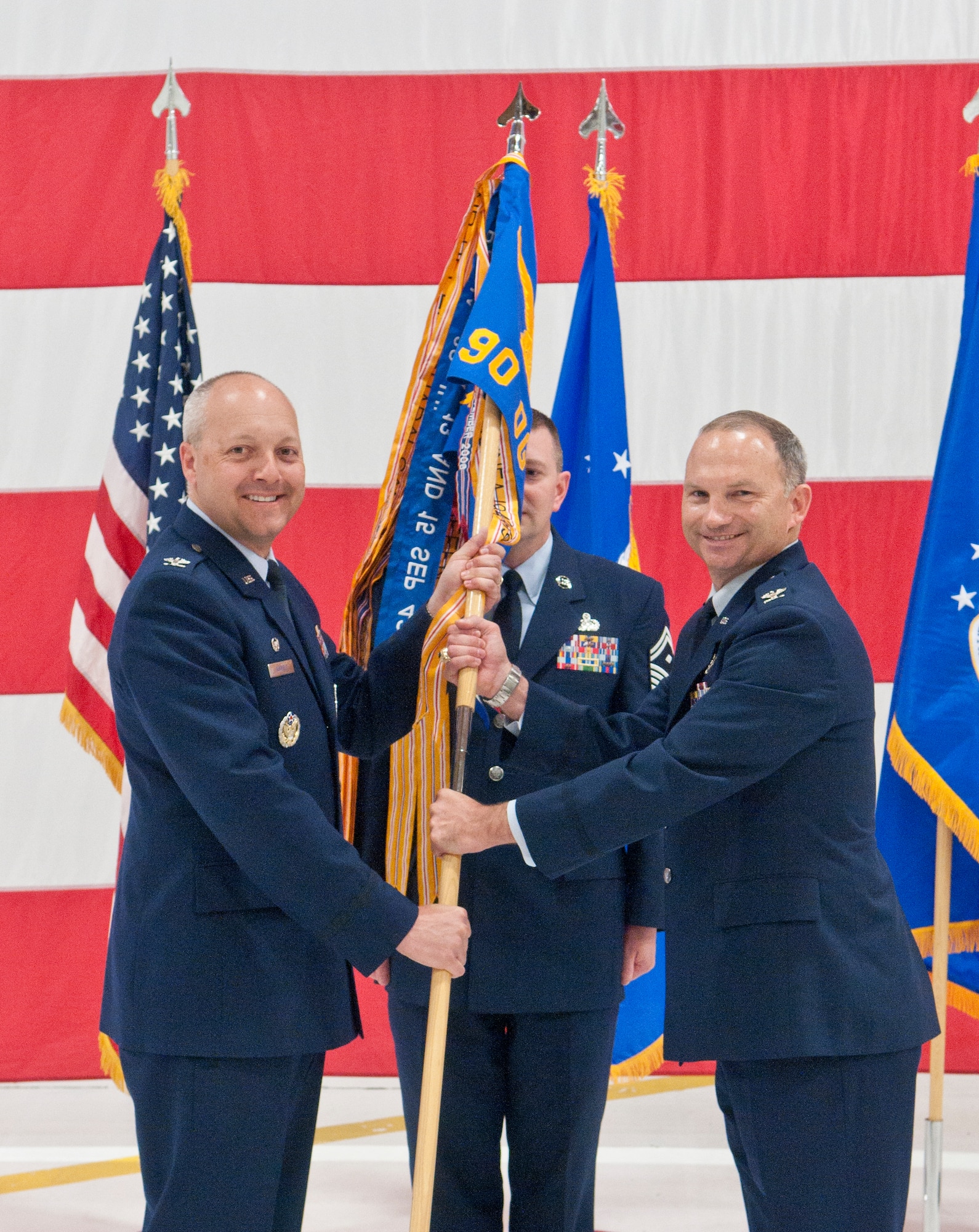 Col. Christopher Coffelt,  90th Missile Wing commander, presents the 90th Operations Group guidon to Col. Donald Holloway, 90th OG commander, during the 90th OG assumption-of-command ceremony in Building 1250 July 6 at F. E. Warren Air Force Base, Wyo. (U.S. Air Force photo by Airman 1st Class Jason Wiese)