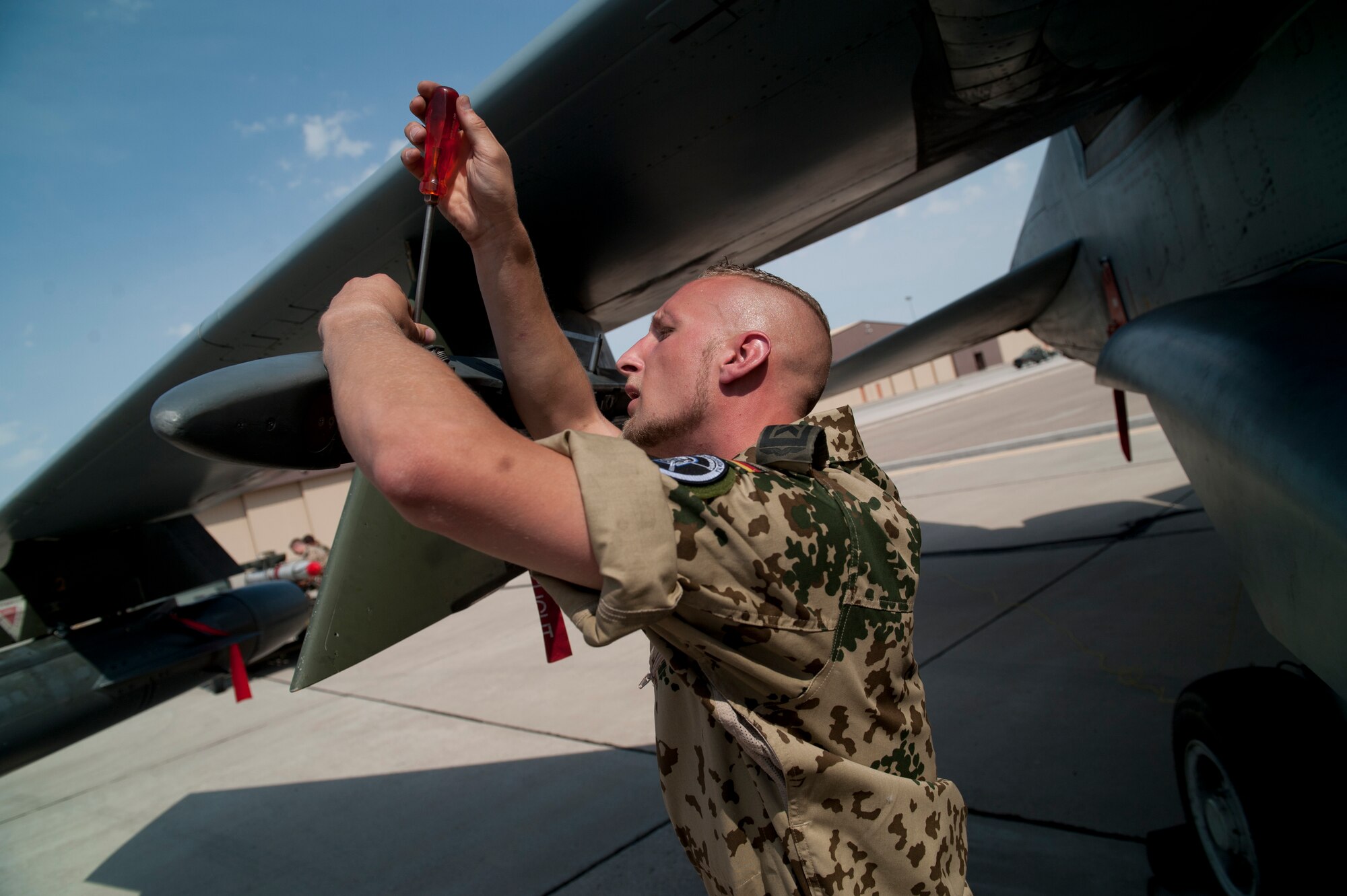 German Air Force Tech. Sgt. Jens Feddersan, German Air Force Flying Training Center crew chief, prepares a Tornado to be loaded with a GBU-24 laser-guided bomb during a quarterly load-crew competition at Holloman Air Force Base, N.M., July 13. The GAF load-crew competed in the load-crew competition to have their skills evaluated alongside the U.S. Air Force F-22 Raptor and MQ-9 Reaper load crews. For the competition, points are awarded during the weapons loading, tool kit inspection, and uniform inspection. (U.S. Air Force photo by Airman First Class Daniel Liddicoet/Released)