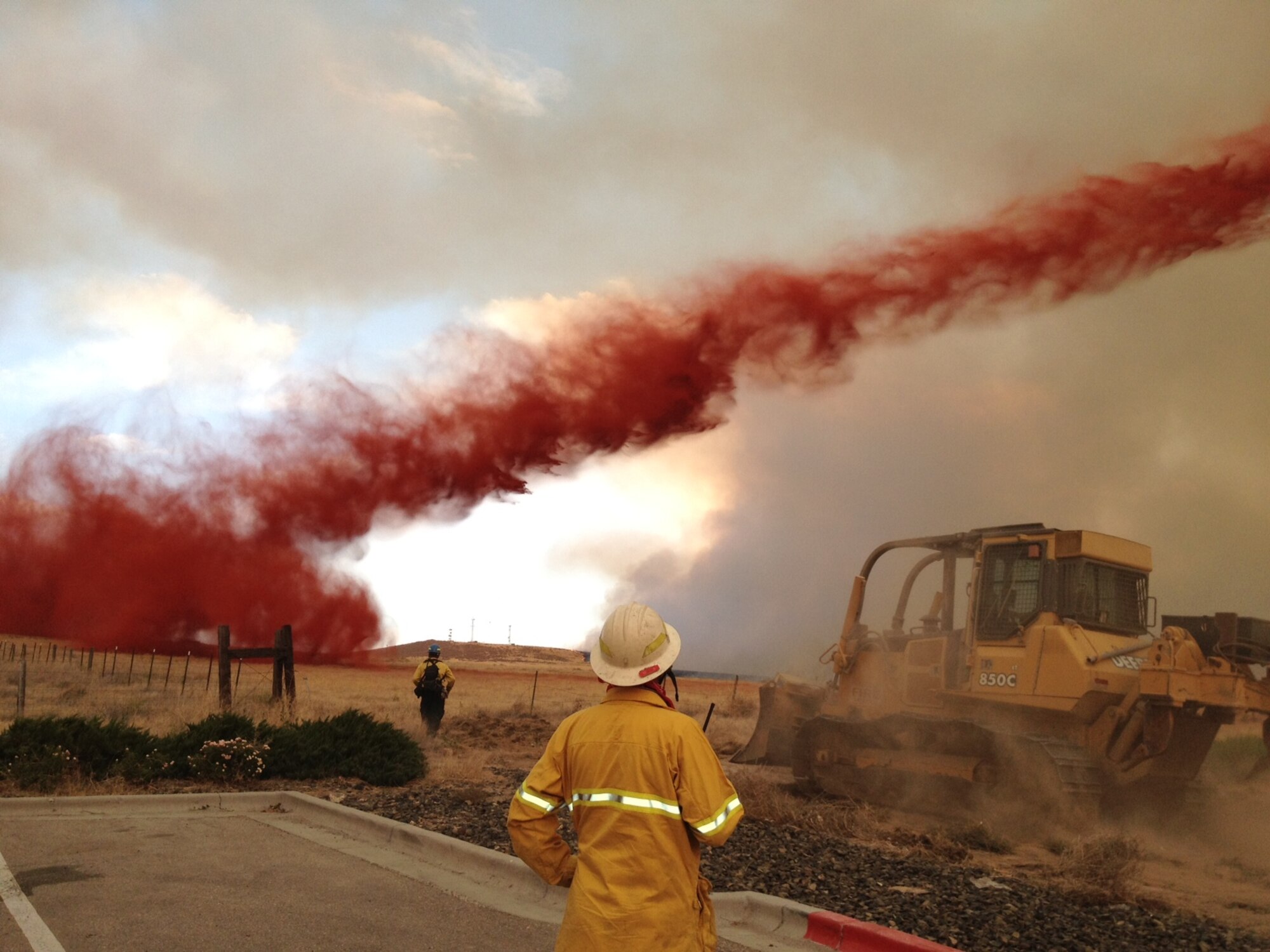A firefighter from Mountain Home Air Force Base, Idaho, watches as a fire break is created  helping protect structures from the Benwalk fire in Mountain Home, Idaho, July 9, 2012. The fire burned more than 25,000 acres and threatened structures near Interstate 84. (U.S. Air Force photo/courtesy Jeff Wagner, MHAFB Deputy Fire Chief)