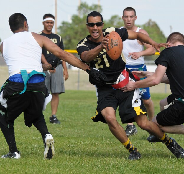 Senior Airman Corey Rucker, 90th Missile Maintenance Squadron facilities maintenance technician, unable to make a pass, scrambles after 90th Logistics Readiness Squadron defenders charge past the line during a flag football tournament hosted by the Under 21 Responsible and Resilient Program July 5 on the F. E. Warren ball fields. The 90th MXG went on to win 18 to 6, taking victory in the tournament. (U.S. Air Force photo by Airman 1st Class Jason Wiese)