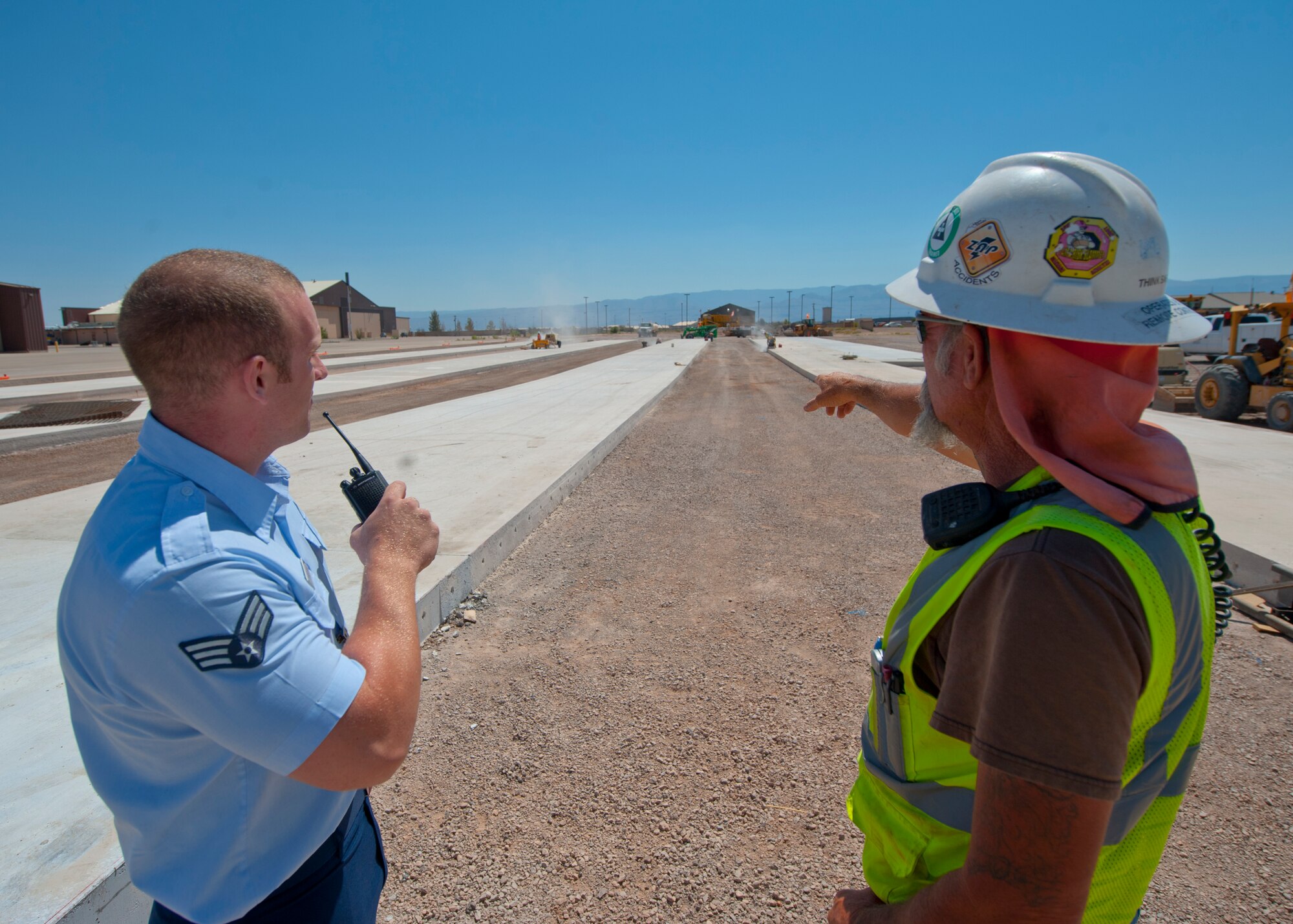 Senior Airman Christopher Proctor, 49th Operations Support Squadron airfield manager, and John Nappier, construction foreman, discuss on-going construction taking place on the airfield at Holloman Air Force Base, N.M., June 25. Airfield management is responsible for overseeing all construction projects taking place on the airfield and ensuring the safety and timeliness of all workers involved. (U.S. Air Force photo by Airman 1st Class Daniel E. Liddicoet/Released)
