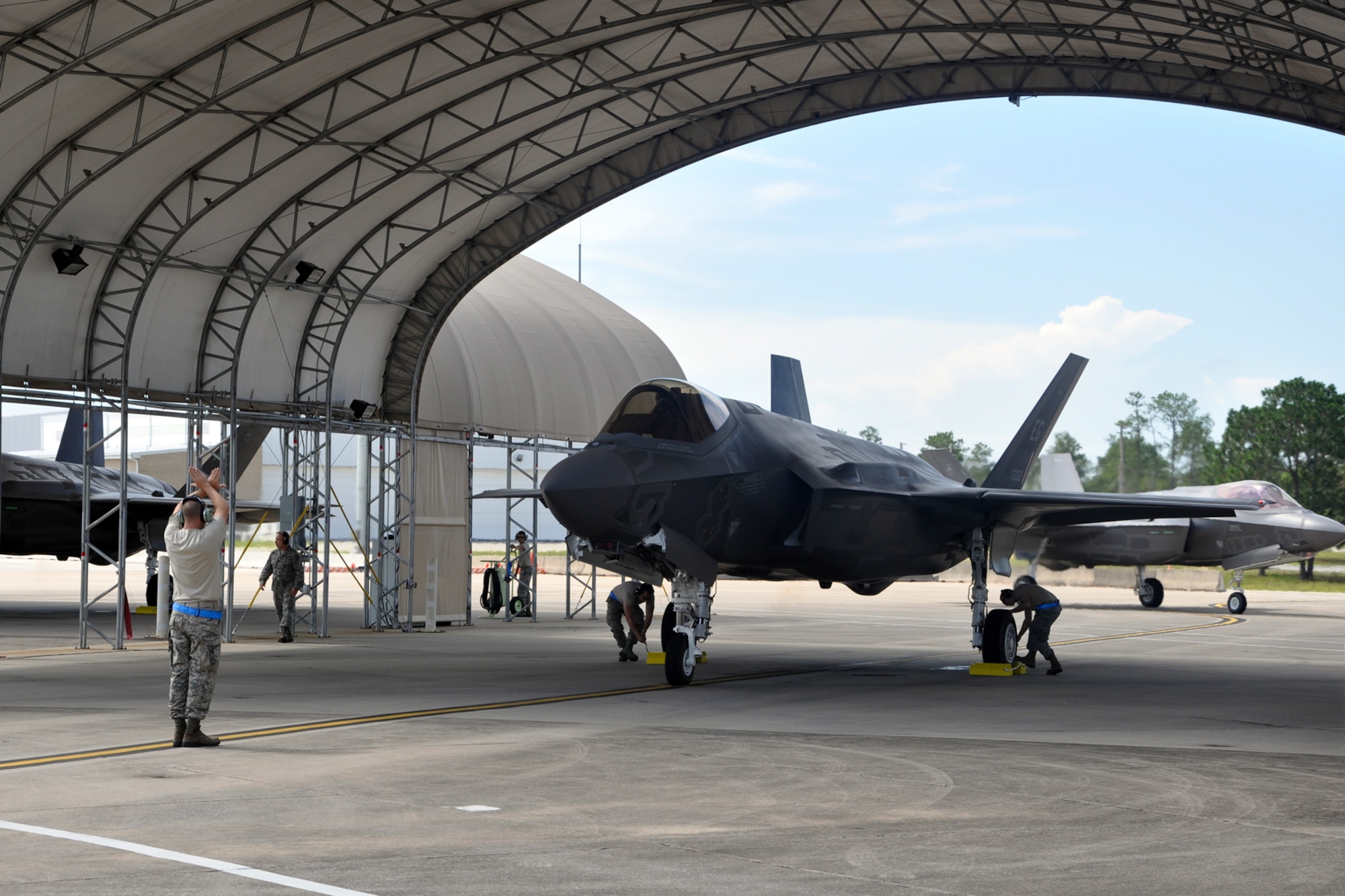 EGLIN AIR FORCE BASE, Fla. -- Staff Sgt. Danny Pereira, 33rd Fighter Wing crew chief, conducts one of the post flight shut downs of three newly arrived F-35A Lightning IIs with pilot Lt. Col. Eric Smith, 58th Fighter Squadron. The wing now has 16 F-35s with the A and B variants combined after today's arrivals. Increasing the fleet continues to increase the ability to qualify additional Air Force and Marine Corps initial cadre as instructor pilots. The F-35 Integrated Training Center at Eglin is preparing for full rate F-35 pilot training for Air Force, Navy, Marine Corps and international pilots in the coming year. (U.S. Air Force photo by Maj. Karen Roganov)