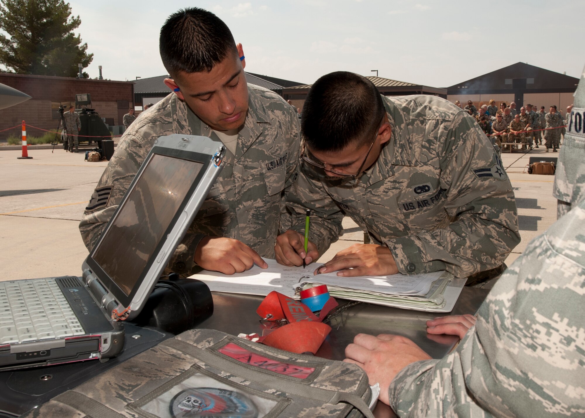 Staff Sgt. Gabrial [last name withheld due to operational security concerns] and Airman 1st Class Binh [last name withheld due to operational security concerns], 49th Maintenance Group, log their work during a quarterly load-crew competition at Holloman Air Force Base N.M., July 13. For load-crew competitions, points are awarded during the actual weapons loading, a tool-kit inspection, and a uniform inspection. The competitions are held to give weapons personnel the opportunity to display their warfighting skills and unveils the best weapons load crew for a particular quarter during the year. (U.S. Air Force photo by Airman Leah Ferrante/Released)
