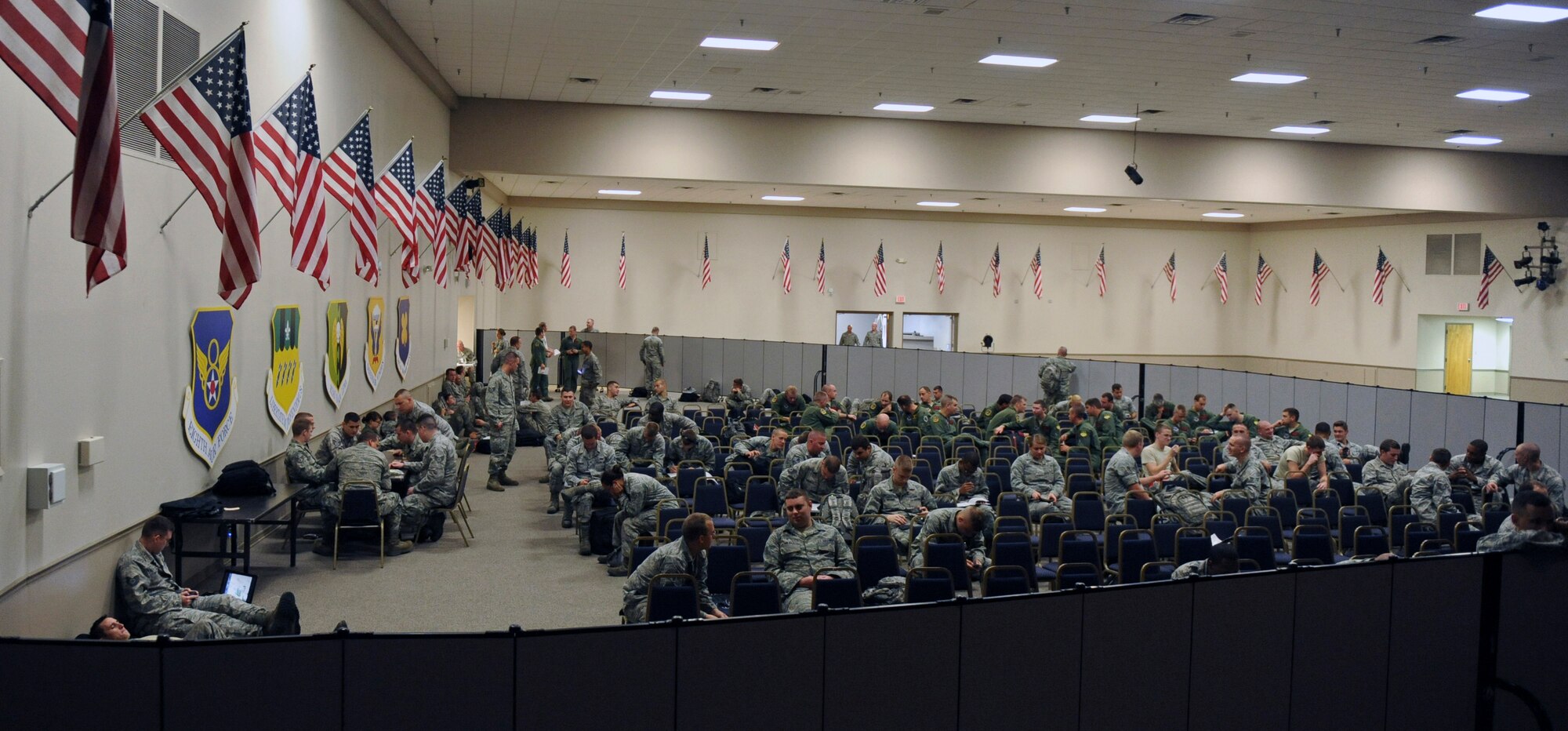 Airmen with temporary duty orders to Nellis Air Force Base, Nev., wait for a chartered flight at Hoban Hall on Barksdale Air Force Base, La., July 12. About 157 maintenance, force support and logistics Airmen along with aircrews left for Nellis to participate in the Red Flag exercise. Red Flag provides realistic combat scenarios for aircrews from the U.S., NATO and allied countries. (U.S. Air Force photo/Airman 1st Class Micaiah Anthony)(RELEASED)