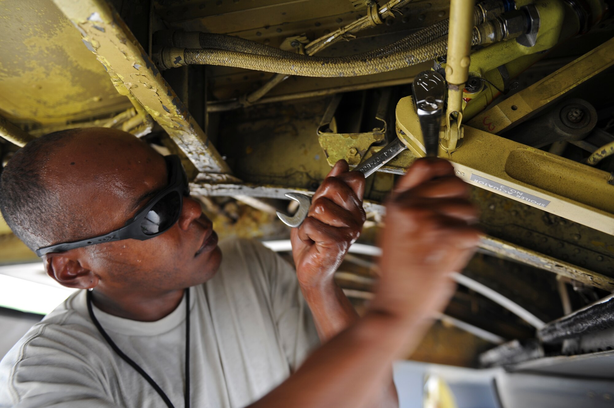 Senior Airman Kern Brathwaite, 2nd Aircraft Maintenance Squadron aircraft pneudraulics journeyman, loosens a bolt to replace a leaking spoiler actuator on a B-52H Stratofortress on Barksdale Air Force Base, La., July 11. The hydraulic replacement was a necessary discrepancy that had to be fixed in order for the aircraft to participate in the Red Flag exercise at Nellis AFB, Nev. Maintenance Airmen worked around-the-clock to ensure all aircraft participating in the exercise were ready. Red Flag provides realistic combat scenarios for aircrews from the U.S., NATO and allied countries. (U.S. Air Force photo/Airman 1st Class Micaiah Anthony)(RELEASED)
