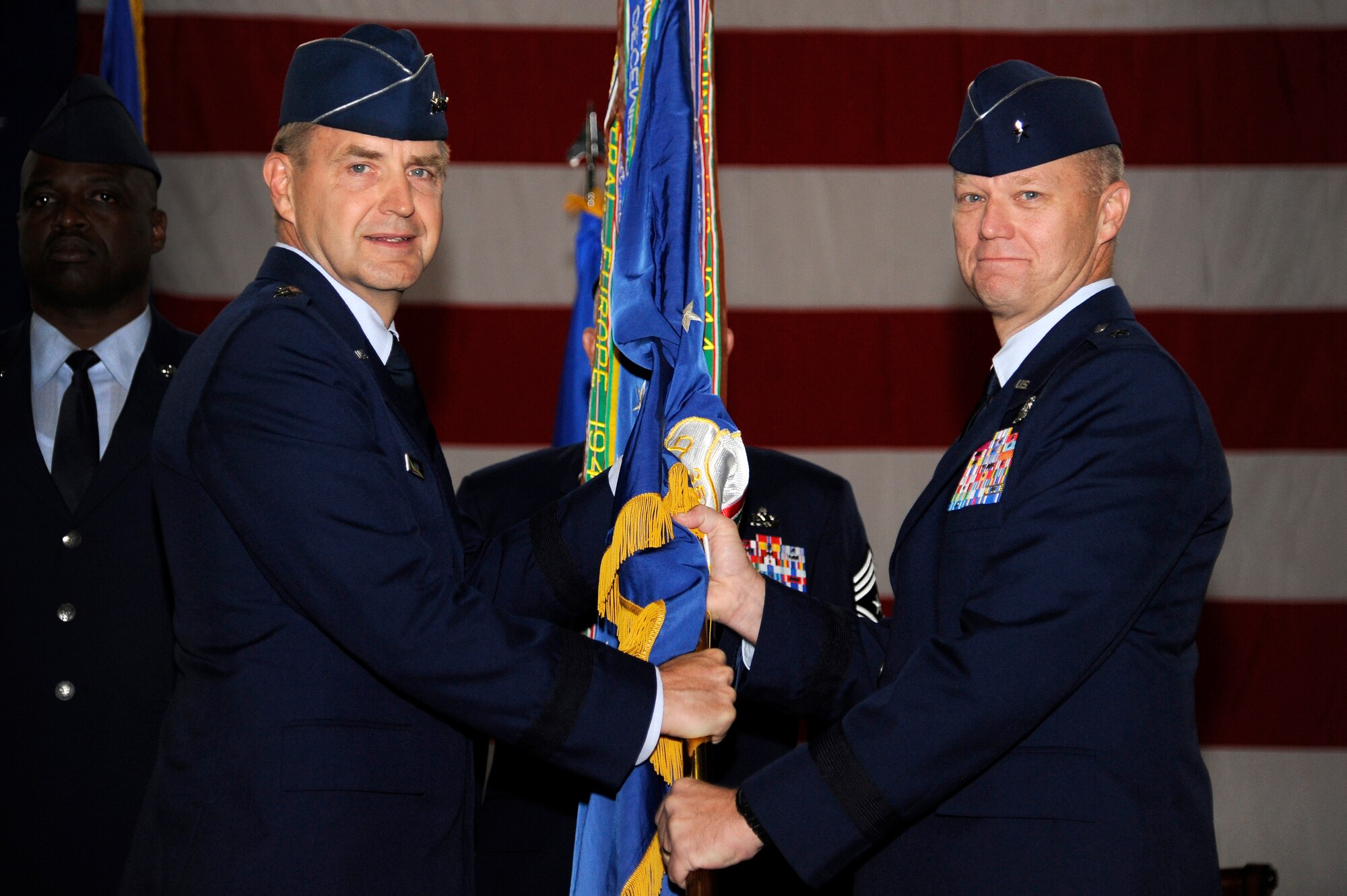 U.S. Air Force Brig. Gen. Mark Kelly, incoming 354th Fighter Wing commander, accepts the guideon from Lt. Gen. Stephen Hoog, Alaskan Command and 11th Air Force commander, during a change command ceremony July 13, 2012, Eielson Air Force Base, Alaska.  The change of command ceremony allows subordinates to witness the formal transfer of total responsibility, authority and accountability from one officer to another. (U.S. Air Force photo/Staff Sgt. Jim Araos) 