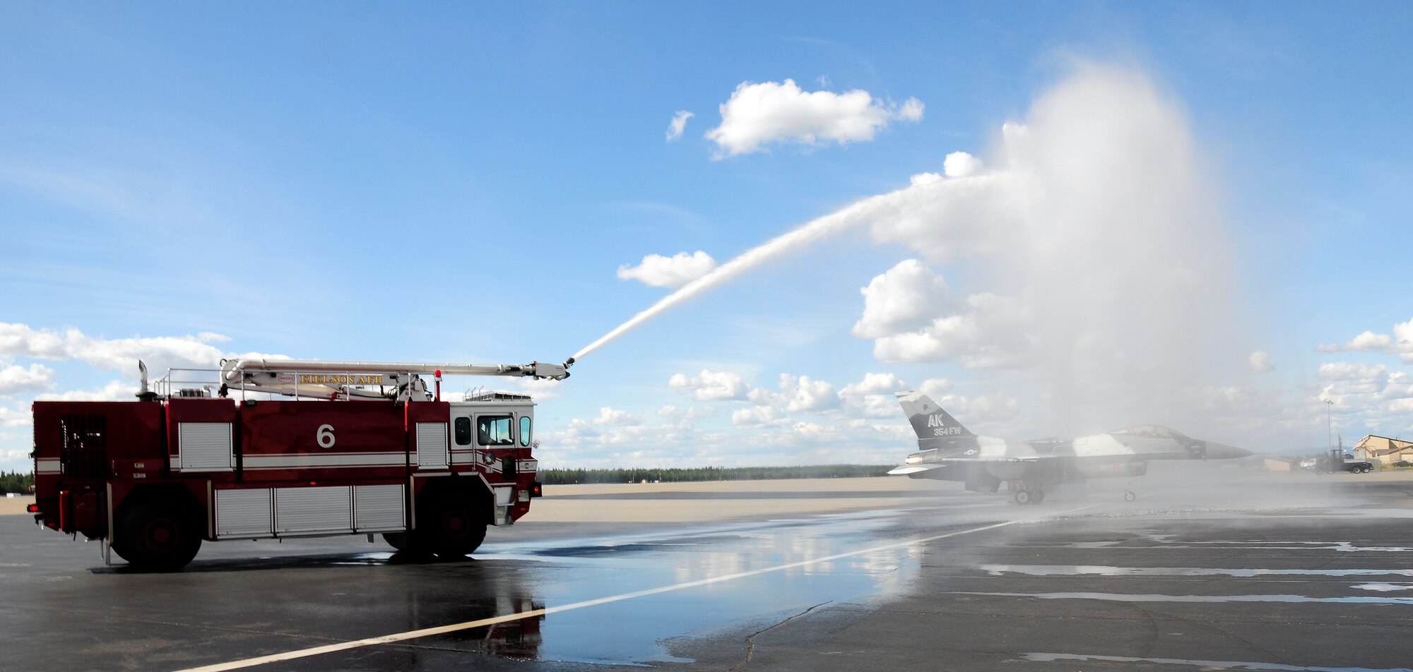 Brig. Gen. James N. Post III, 354th Fighter Wing commander, taxis through an archway of water upon completion of his final flight July 12, Eielson Air Force Base, Alaska. The final flight is an aviation tradition in which aircrew members, upon completion of their last flight with the wing, or "fini flight," are met and hosed down with water by their squadron comrades, family and friends. (U.S. Air Force photo/Airman 1st Class Zachary Perras)