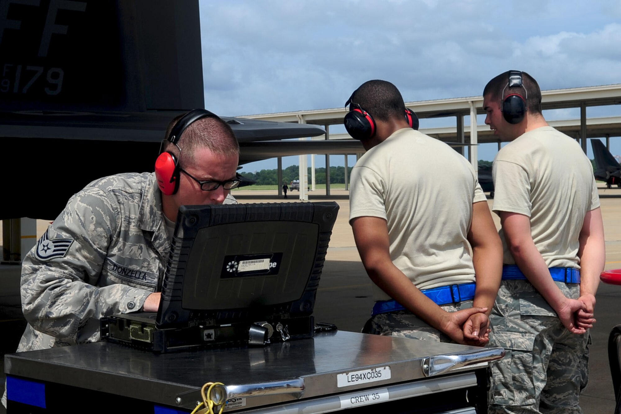 U.S. Air Force Staff Sgt. Derek Donzella, 94th Aircraft Maintenance Unit weapons loader, uses a computer to check all finished requirements, while Airmen 1st Class Gregory Peterson, middle, and John Brondsema wait for the finishing time, during a weapons loading competition at Langley Air Force Base, Va., July 12, 2012. The 94th AMU won with a time of 18:02 against the 27th AMU’s time of 19:55. (U.S. Air Force photo by Staff Sgt. Ashley Hawkins/Released)