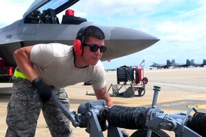 U.S. Air Force Airman 1st Class Kohlin Martin, 27th Aircraft Maintenance Unit weapons loader, prepares to load ordnance onto an F-22 Raptor during the 2nd quarter weapons loading competition at Langley Air Force Base, Va., July 12, 2012. The 27th AMU and 94th AMU compete quarterly, showcasing their abilities to quickly and accurately load weapons. (U.S. Air Force photo by Staff Sgt. Ashley Hawkins/Released)