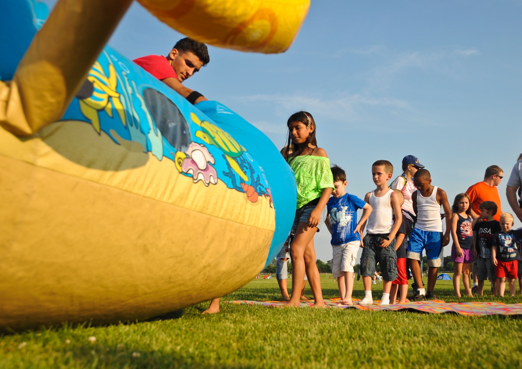 Children wait in line to enter the Under the Sea Adventures inflatable fun house during the annual Fourth of July celebration at Doughboy Field July 4 here. Attendees participated in various activities to include bouncy castles, face painting, go-carts and mini golf as the joint base celebrated America’s Independence Day. (U.S. Air Force photo by Staff Sgt. David Carbajal/Released) 