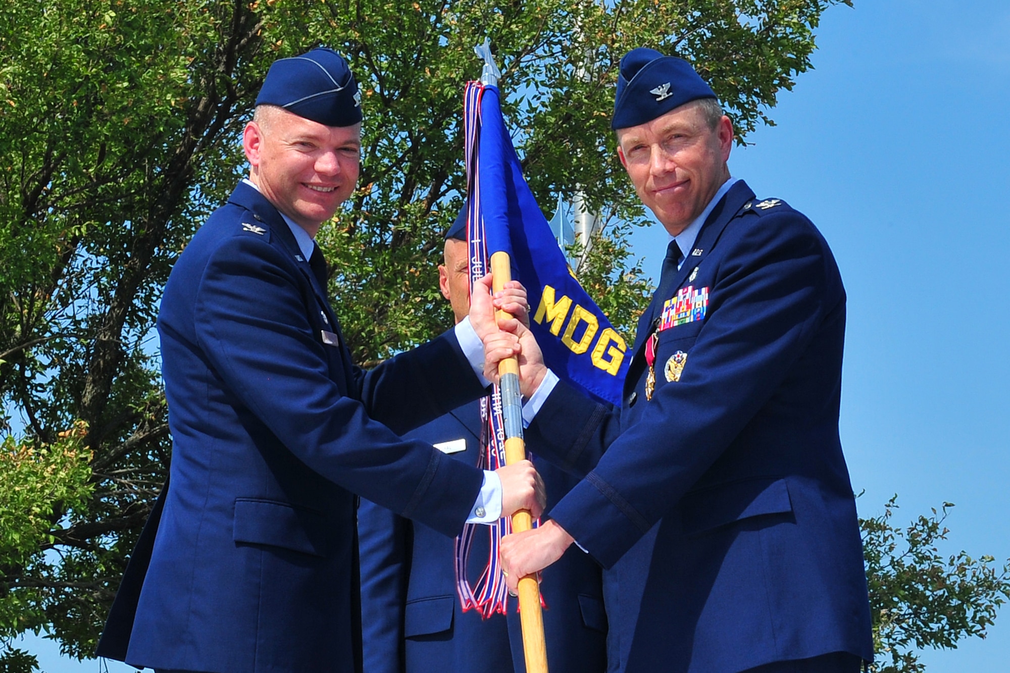U.S. Air Force Col. John Rauch, 55th Wing commander, receives the 55th Medical Group guidon from outgoing 55th MDG commander U.S. Air Force Col. Patrick Dawson, during the 55th MDG change of command ceremony held outside the Ehrling Bergquist Clinic on Offutt Air Force Base, Neb., July 12. Dawson has been selected as the Medical Service Corps director, Office of the Air Force Surgeon General in Washington D.C. 