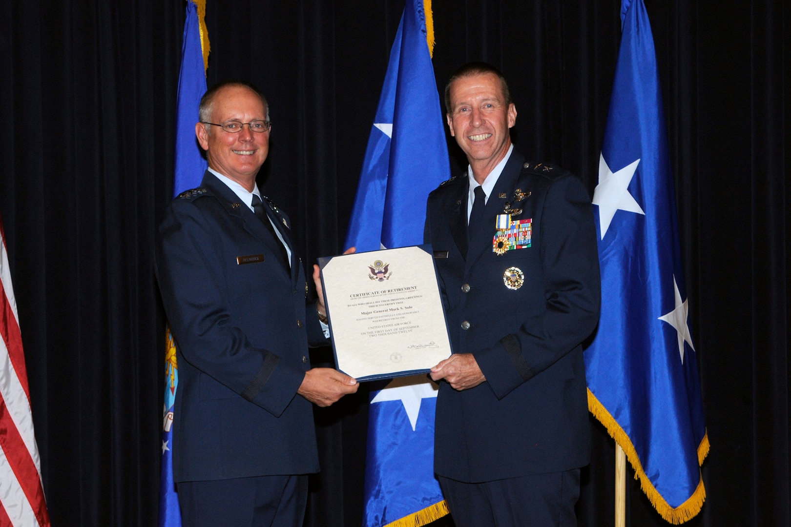 Lt. Gen. Robert Allardice, Air Mobility Command vice commander, presents a certificate of retirement to Maj. Gen. Mark Solo, 19th Air Force commander, at Joint Base San Antonio-Randolph, Texas, July 13.  Solo's retirement came the day after the inactivation of the 19th AF. (U.S. Air Force photo by Don Lindsey) 