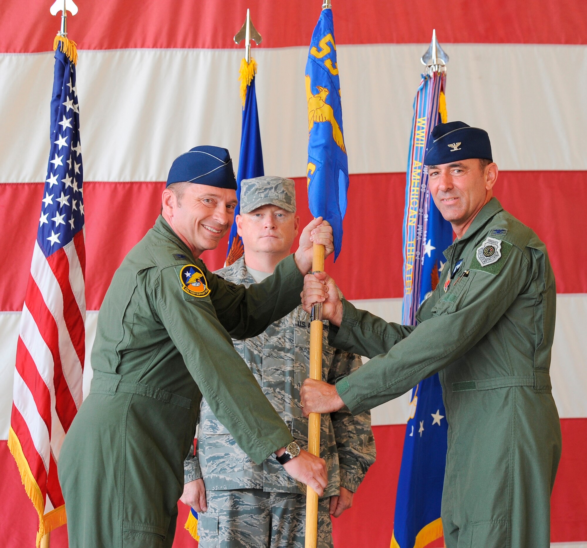 Colonel David Hicks (Left), 53rd Wing commander, Eglin Air Force Base, Fla., passed the 53rd Weapons Evaluation Group guidon to Col. James Vogel (Right) who assumed command of the 53rd WEG in an assumption of command ceremony, July 13, as Master Sgt. Toby Spraberry (Center), 53rd WEG first sergeant, looked on. (U.S. Air Force photo by Lisa Norman) 