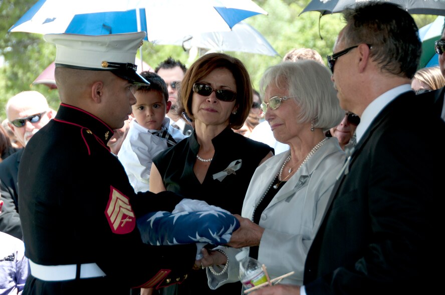 A United States Marine presents the folded U.S. flag to Bill Valenzuela’s wife Celina at Holy Hope Cemetery in Tucson, Ariz., July 12. Valenzuela and his wife raised five daughters, and one son; as well as 17 grandchildren, and 12 great grandchildren. (U.S. Air Force photo/ Master Sgt. Dave Neve)