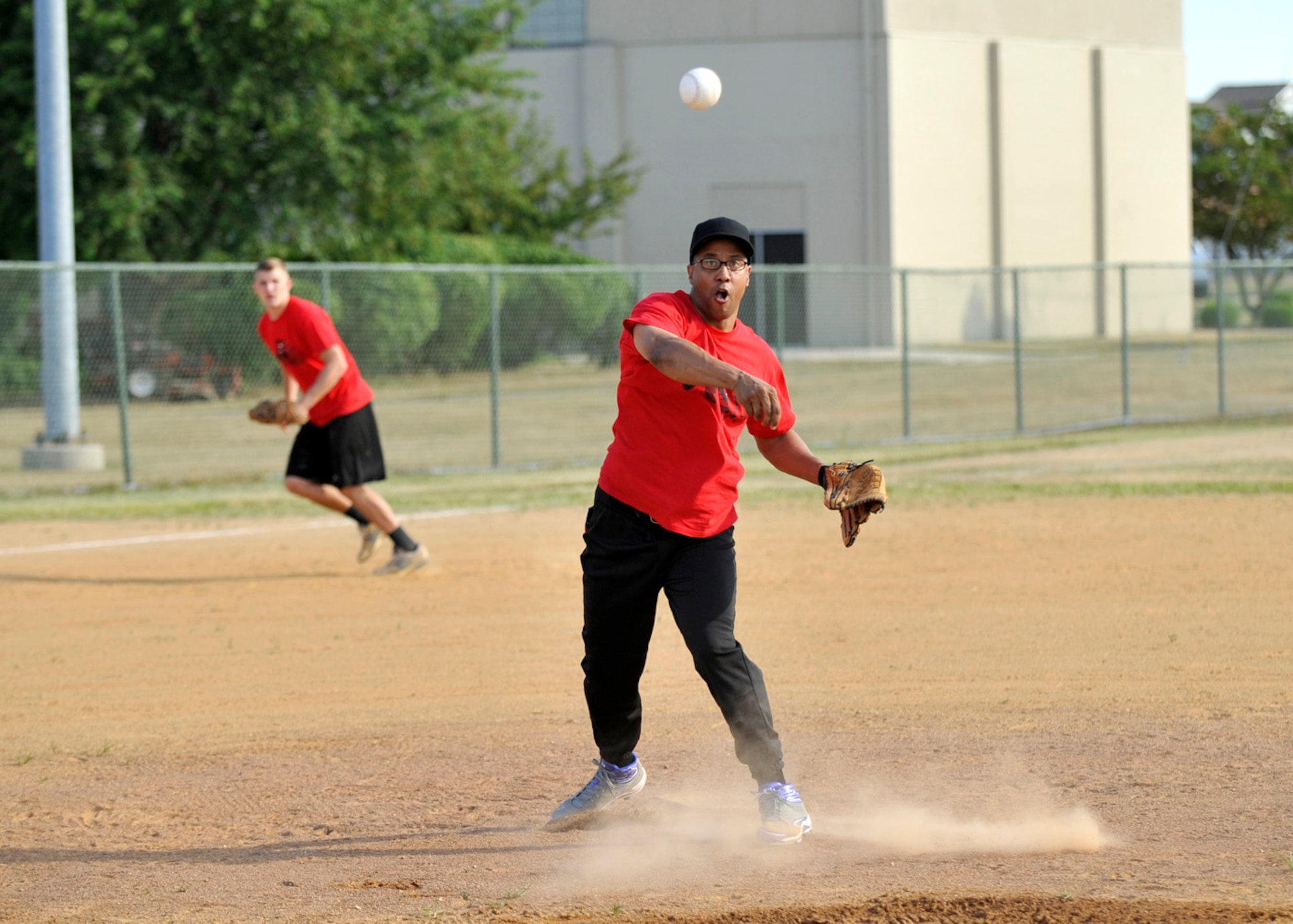 James McDonald, pitcher for the 436th Aerial Port Squadron, throws a runner out at first base during a National League intramural softball game against the 9th Airlift Squadron July 12, 2012, at Dover Air Force Base, Del. The 436th APS remained unbeaten defeating the 9th AS 15-5 in five innings. (U.S. Air Force photo by Tech. Sgt. Chuck Walker)