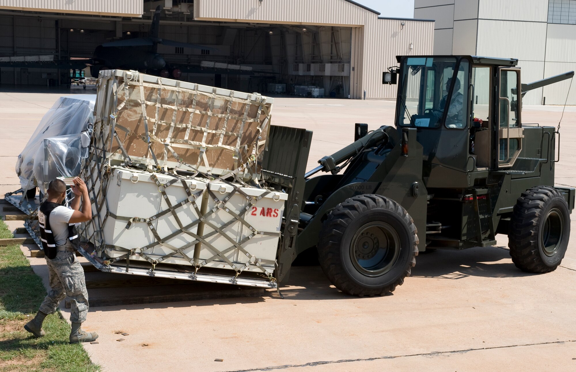 U.S. Air Force Staff Sgt. Alfredo Saldana, left, and Senior Airman Andreous Knight, 7th Logistics Readiness Squadron, position a cargo pallet into place during an Operational Readiness Exercise July 12, 2012, at Dyess Air Force Base, Texas. Processing cargo quickly and accurately is a vital part of getting the equipment where it needs to be.  Airmen from the 7th LRS must ensure the cargo is weighed properly, secure and safe before it is loaded on the aircraft. (U.S. Air Force photo by Staff Sgt. Richard P. Ebensberger/ Released)