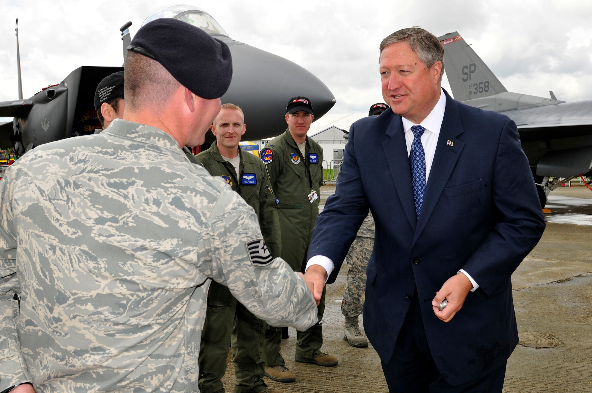 FARNBOROUGH, England - Secretary of the Air Force Michael Donley shakes hands with Tech. Sgt. Robert Webb, 48th Security Forces Squadron security team lead, July 10, 2012, during a visit to the Farnborough International Air Show in Farnborough, England. Approximately 90 aircrew and support personnel from bases in Europe and the United States are participating in the air show. Participation in this premier event demonstrates that U.S. defense industry offers state-of-the-art capabilities vital for the support and protection of our Allies' and Partners' national-security interests. (U.S. Air Force photo by Tech. Sgt. Lee A. Osberry Jr.)