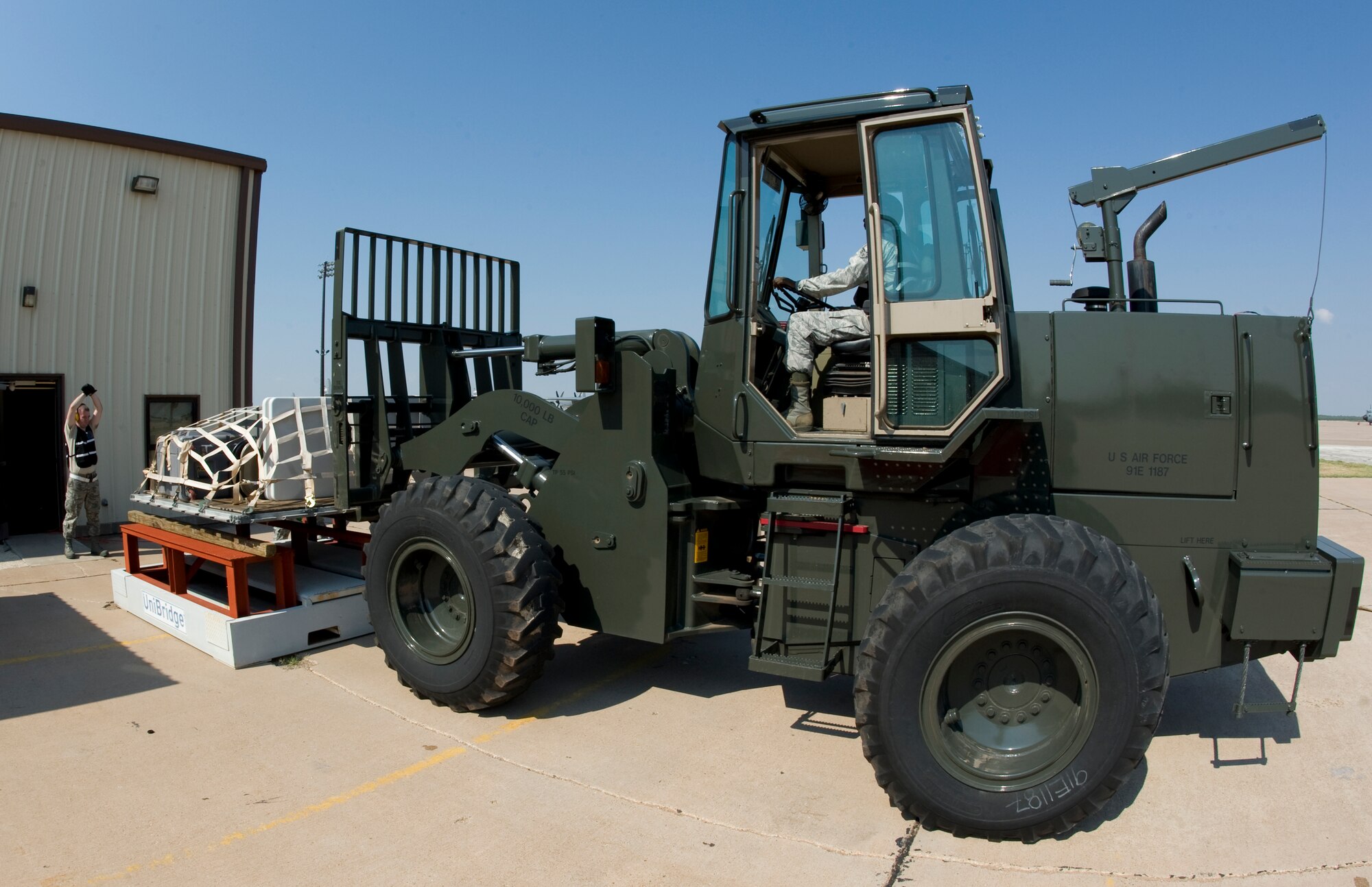 U.S. Air Force Staff Sgt. Zachary Harter, left, and Senior Airman Andreous Knight, 7th Logistics Readiness Squadron, position a cargo pallet onto a weight scale during an Operational Readiness Exercise July 12, 2012, at Dyess Air Force Base, Texas. Processing cargo quickly and accurately is a vital part of getting the equipment where it needs to be.  Airmen from the 7th LRS must ensure the cargo is weighed properly, secure and safe before it is loaded on the aircraft. (U.S. Air Force photo by Staff Sgt. Richard P. Ebensberger/ Released)