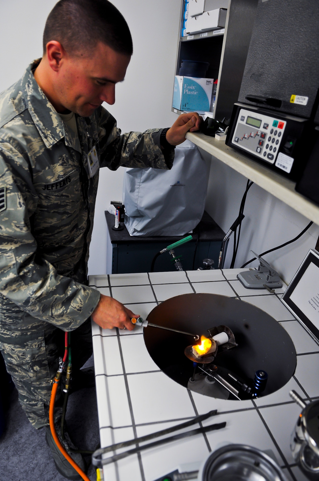 Staff Sgt. Matthew Jefferys, 56th Dental Squadron dental lab technician, melts a small piece of gold to create a gold tooth implant. The gold is heated by hand and spun quickly into the tooth mold. (U.S. Air Force photo by Senior Airman C.J. Hatch)	