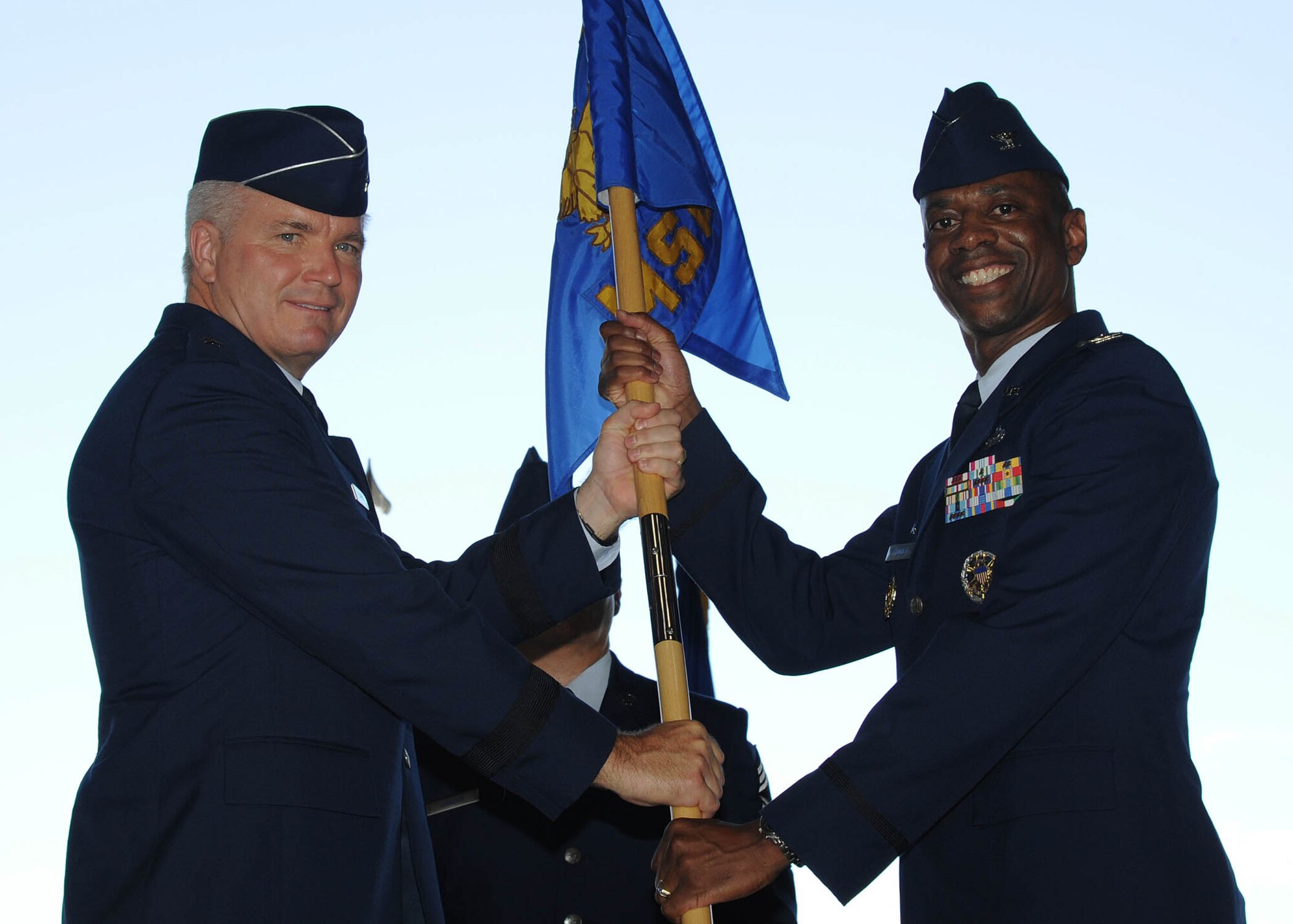 Brig. Gen. JD Harris, 56th Fighter Wing commander, passes the guidon to Col. Nathan Mooney Monday as he assumes command of the 56th Mission Support Group during a change-of-command ceremony at Luke Air Force Base. (U.S. Air Force photo by Staff Sgt. Darlene Seltmann)	