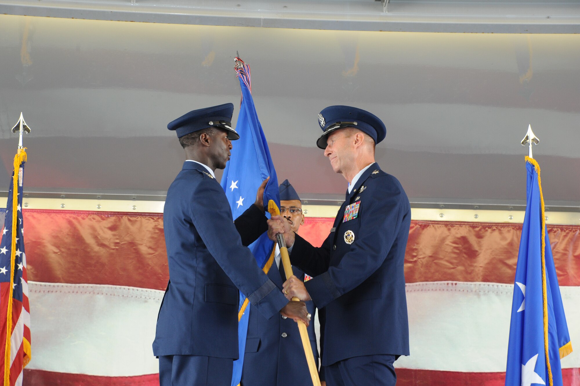 Maj. General Mark Solo (right), 19th Air Force commander, passes the 19th AF flag to Gen. Edward A. Rice Jr., Air Education and Training Command commander, to relinquish command during the inactivation ceremony held at Joint Base San Antonio-Randolph, Texas, July 12. (U.S. Air Force photo by Rich McFadden) 