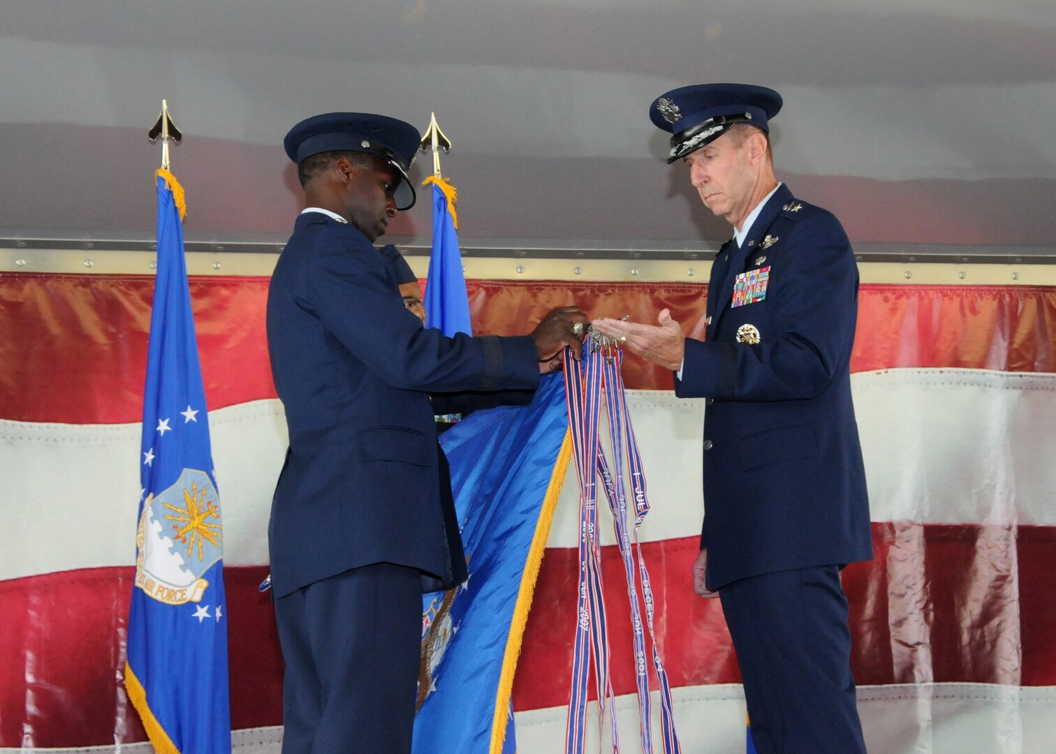 Gen. Edward A. Rice Jr. (left) Air Education and Training Command commander, and Maj. Gen. Mark Solo, 19th Air Force commander, places the outstanding unit award streamer on the 19th AF flag at the inactivation ceremony held at Joint Base San Antonio-Randolph, Texas, July 12. (U.S. Air Force photo by Melissa Peterson)
