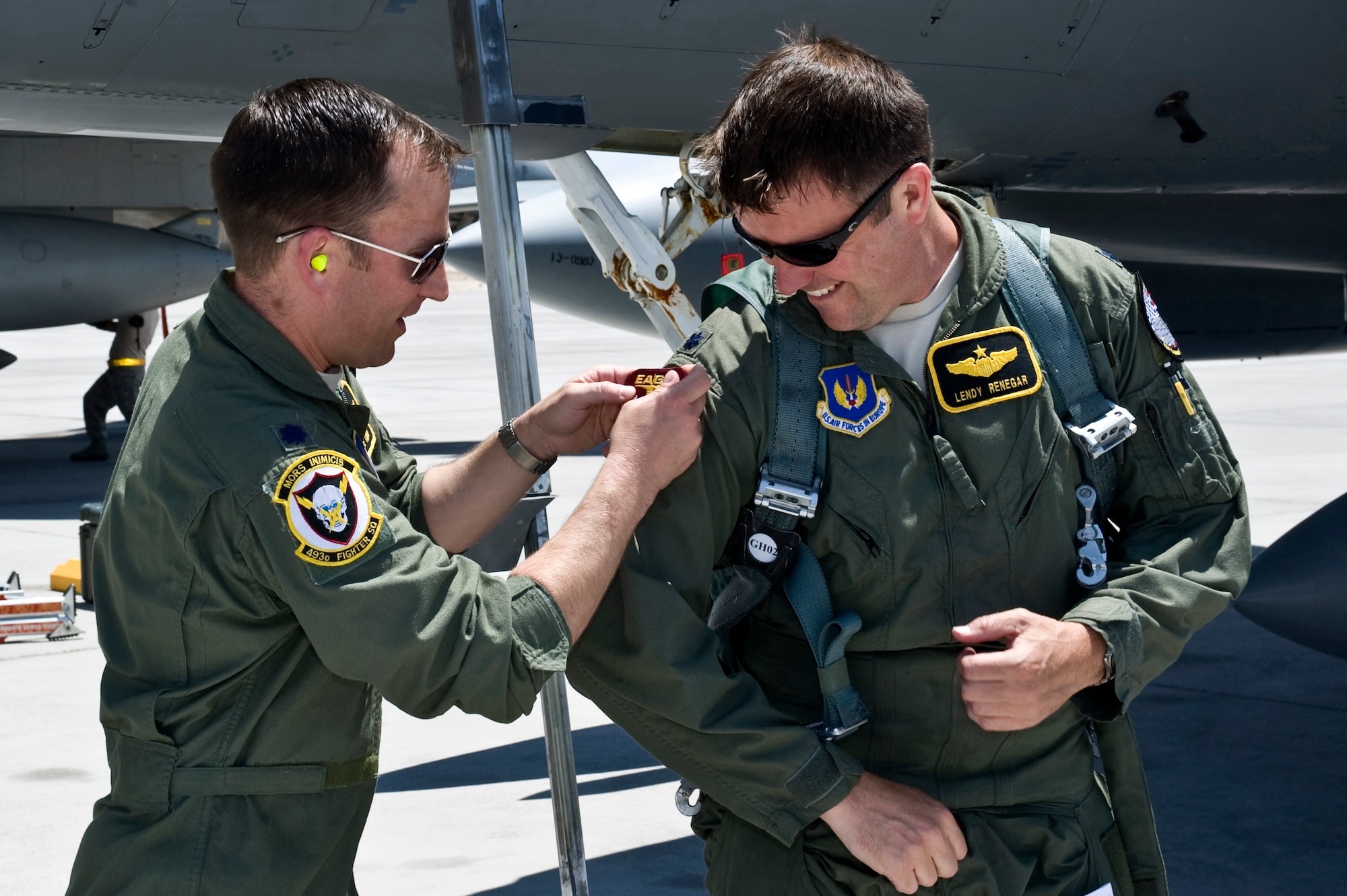 ROYAL AIR FORCE LAKENHEATH, England - Lt. Col. Mike Casey, 493rd Fighter Squadron commander, puts an Eagle 2,000 hours flying patch on Lt. Col. Lendy Renegar, 493rd FS director of operations, after Renegar landed at Nellis Air Force Base, Nev., July 10, 2012.  Renegar reached 2,000 flying hours in and F-15C Eagle flying over the Atlantic Ocean to take part in Red Flag at Nellis AFB, Nev. (Courtesy photo)