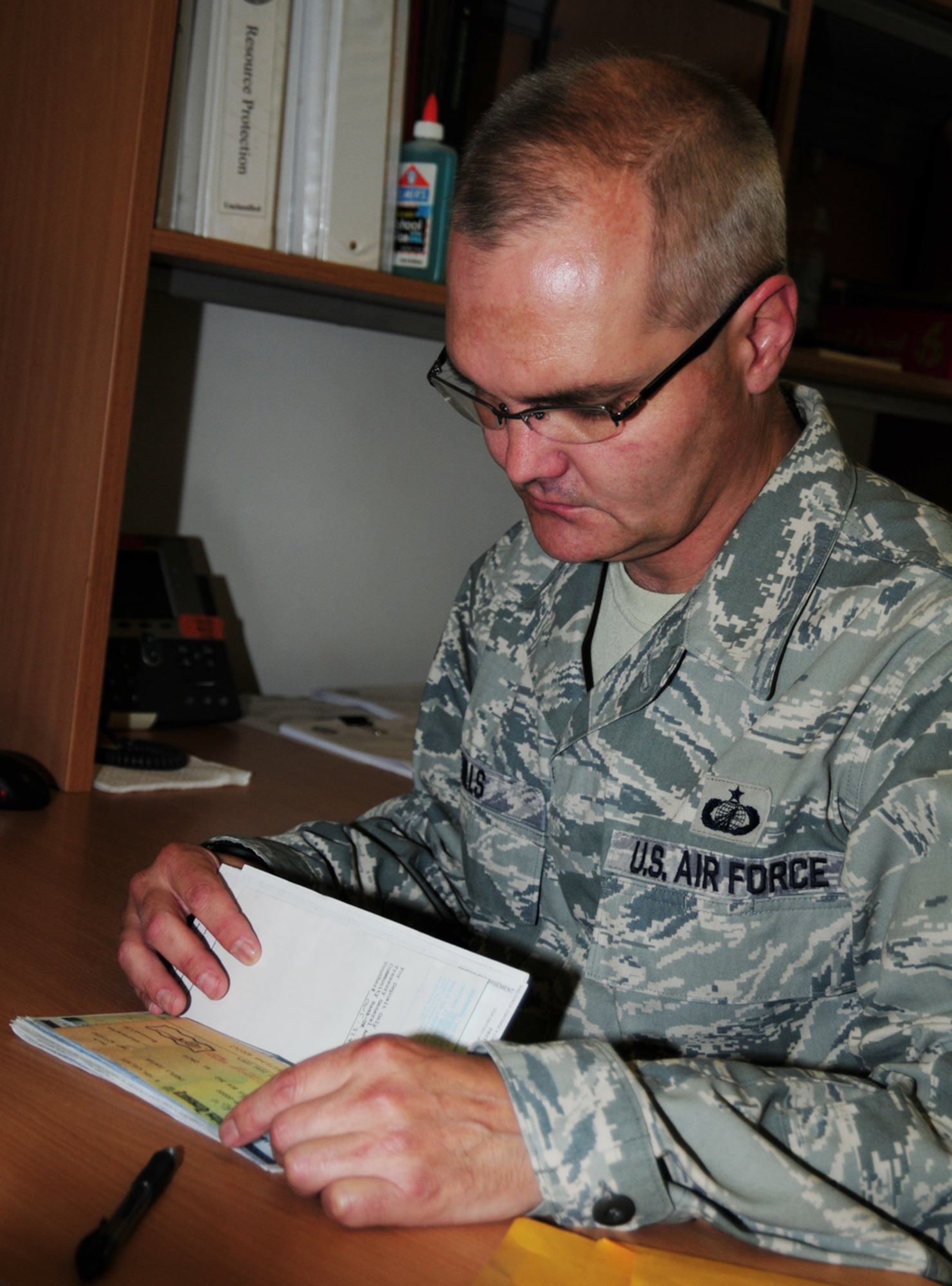 RAF MILDENHALL, England – Tech. Sgt. James Mills, 100th Comptroller Squadron deputy disbursing officer, goes through old checks to ensure they can be destroyed July 9, 2012. Once the checks have been scanned and sent to the U.S. Department of the Treasury, paper copies are no longer required and can be shredded. All checks are destroyed in a secure manner to prevent any reconstruction. (U.S. Air Force photo/Karen Abeyasekere)