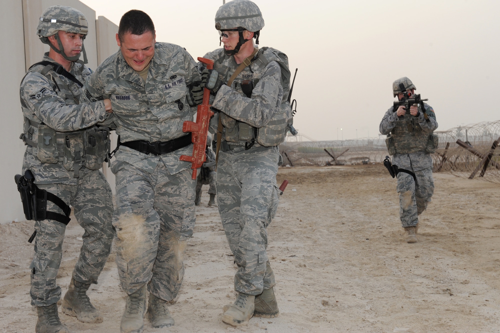 SOUTHWEST ASIA - U.S. Air Force Airman 1st Class Dustin Burnett and Staff Sgt Devin Banks, 380th Expeditionary Security Forces Squadron Quick Response Force members, apprehend Staff Sgt. Ryan Hushour while other members of the QRF team provide security during an intruder-on-base exercise July 12, 2012. The QRF conducts exercises every shift to prepare to respond to any hostile action against the base. (U.S. Air Force photo/Master Sgt. Scott MacKay)