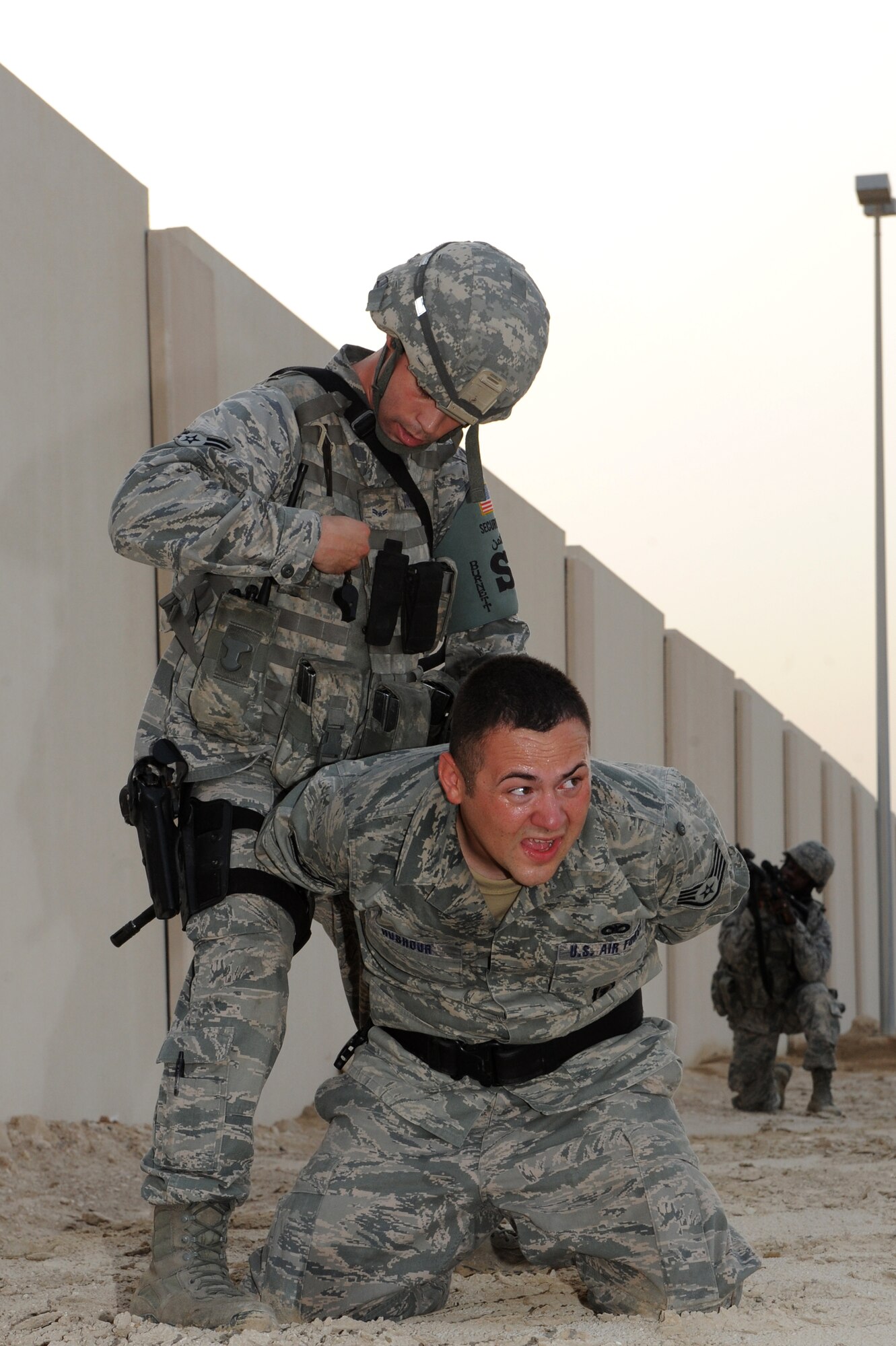 SOUTHWEST ASIA - U.S. Air Force Airman 1st Class Dustin Burnett arrests Staff Sgt. Ryan Hushour during an intruder-on-base exercise July 12, 2012. The QRF conducts exercises every shift to prepare to respond to any hostile action against the base. (U.S. Air Force photo/Master Sgt. Scott MacKay)