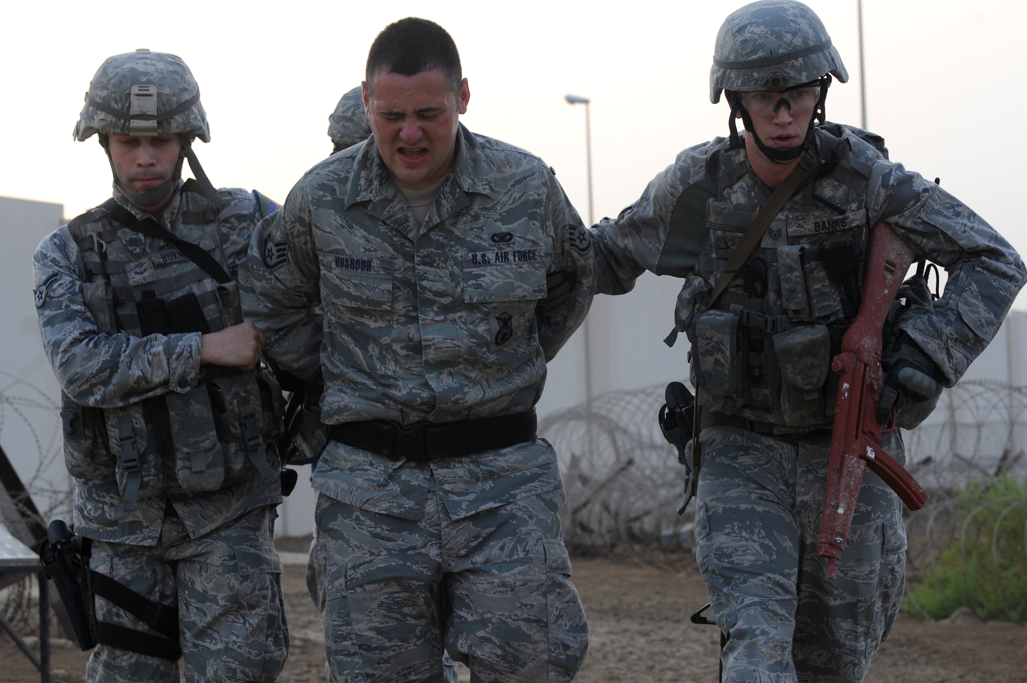 SOUTHWEST ASIA - U.S. Air Force Airman 1st Class Dustin Burnett and Staff Sgt Devin Banks, 380th Expeditionary Security Forces Squadron Quick Response Force members, apprehend Staff Sgt. Ryan Hushour during an intruder-on-base exercise July 12, 2012. The QRF responds to any hostile threat against the base in five minutes or less. (U.S. Air Force photo/Master Sgt. Scott MacKay)