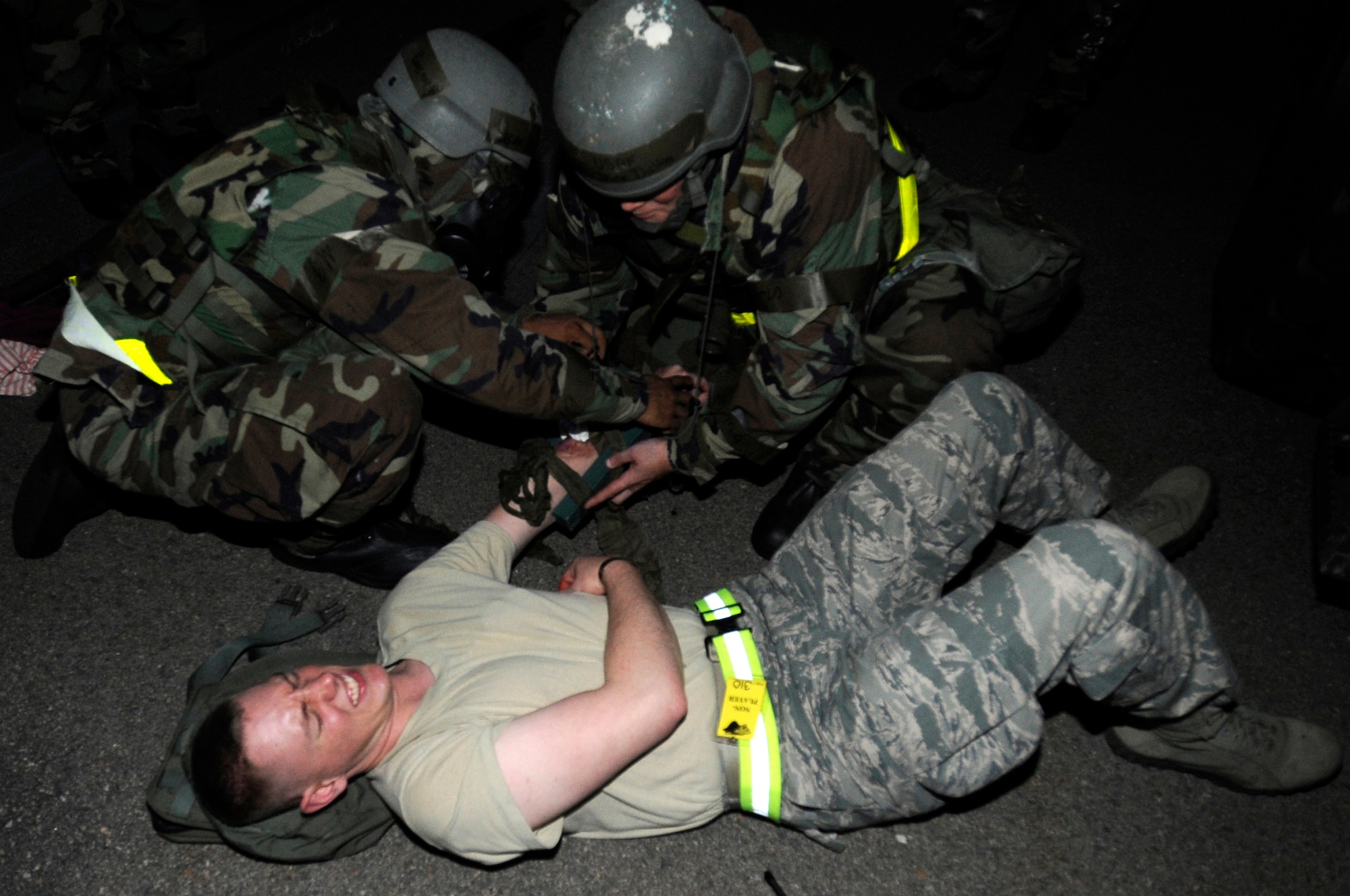 Airmen of the 8th Logistics Readiness Squadron perform self-aid buddy care on Senior Airman Andrew Holcomb, 8th Security Forces Squadron role player, during a readiness exercise at Kunsan Air Base, Republic of Korea, July 11, 2012. Kunsan Airmen practice operational readiness exercises to maintain proficiency for wartime conditions. (U.S. Air Force photo/Master Sgt. Sabrina Johnson)