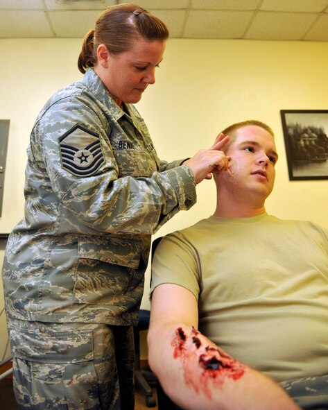 Master Sgt. Heather Bennett, left, 8th Medical Support Squadron applies moulage on Airman 1st Class Nathanial Walker, 8th Maintenance Squadron during the Beverley Midnight 1203 exercise at Kunsan Air Base, Republic of Korea, July 11, 2012. Bennett provides realistic wounds for self-aid buddy care that would be seen in real wartime conditions. (U.S. Air Force photo/ Senior Airman Marcus Morris)
