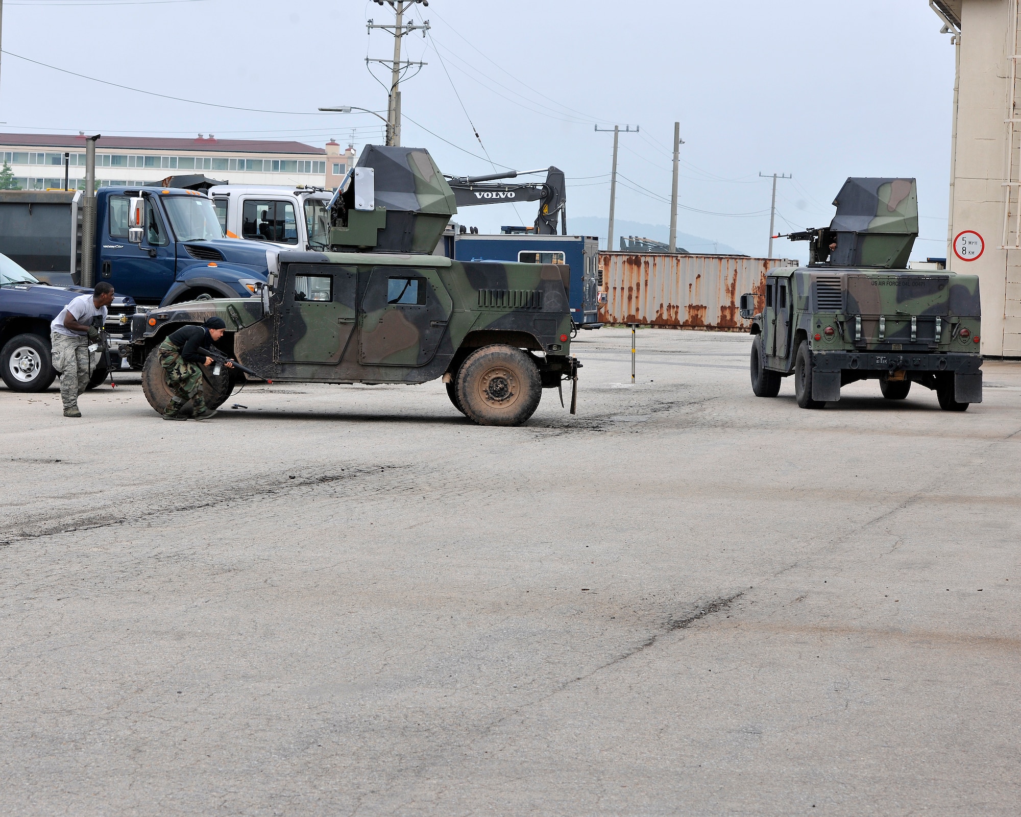 Opposing-forces role players circle around an empty Humvee while dodging fire from another Humvee during exercise Beverly Midnight 12-03 on Kunsan Air Base, Republic of Korea, July 11, 2012. The role players were part of a simulated ground attack with the purpose of evaluating the base’s response to this type of an attack. (U.S. Air Force photo/Staff Sgt. Jonathan Fowler)