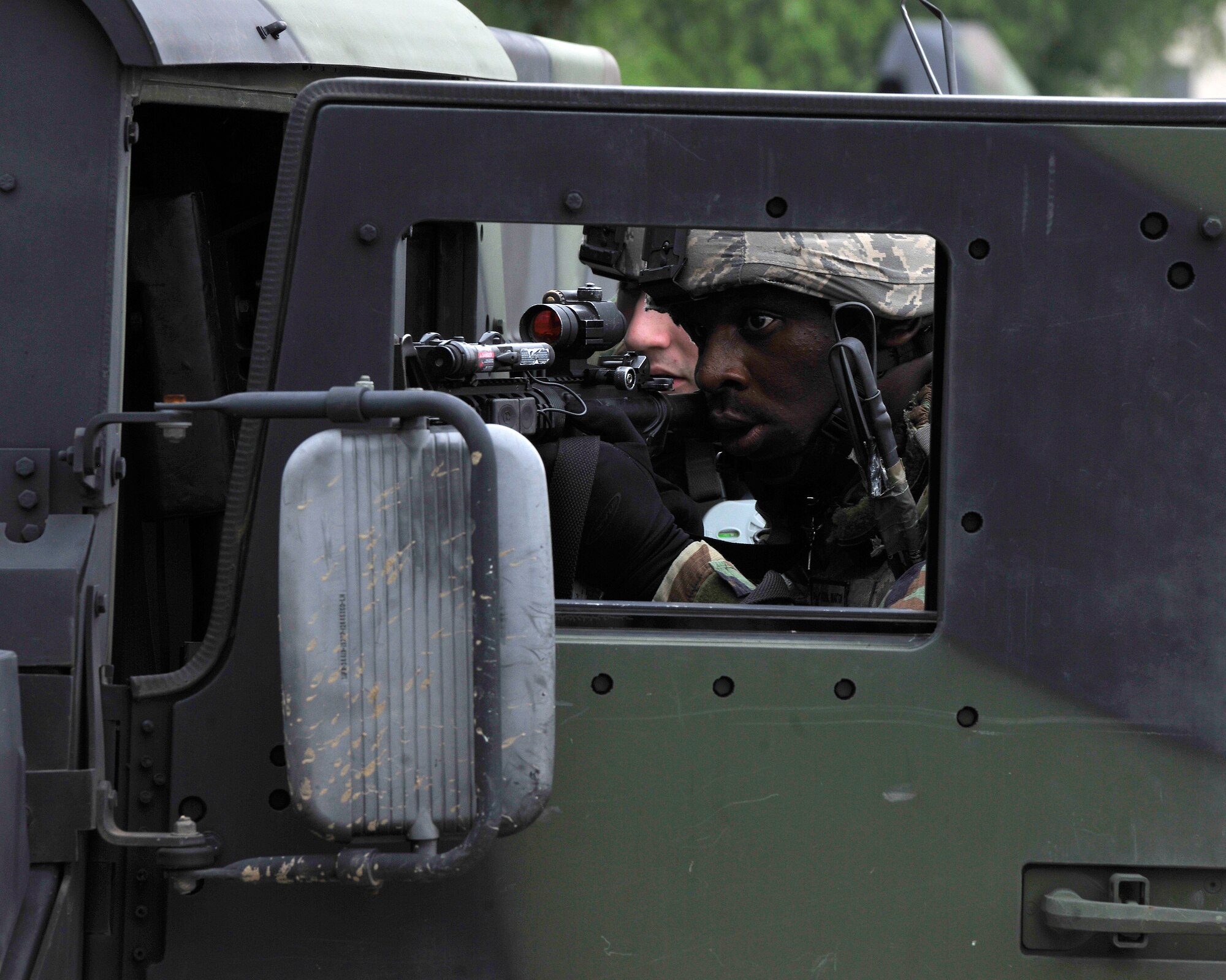 Staff Sgt. Koreal Braxton, 8the Security Forces Squadron, takes cover behind a Humvee door during a simulated ground attack during exercise Beverly Midnight 12-03 on Kunsan Air Base, Republic of Korea, July 11,2012. The scenario tested their ability to respond and neutralize this type of threat to the base. (U.S. Air Force photo/Staff Sgt. Jonathan Fowler)