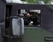 Staff Sgt. Koreal Braxton, 8the Security Forces Squadron, takes cover behind a Humvee door during a simulated ground attack during exercise Beverly Midnight 12-03 on Kunsan Air Base, Republic of Korea, July 11,2012. The scenario tested their ability to respond and neutralize this type of threat to the base. (U.S. Air Force photo/Staff Sgt. Jonathan Fowler)