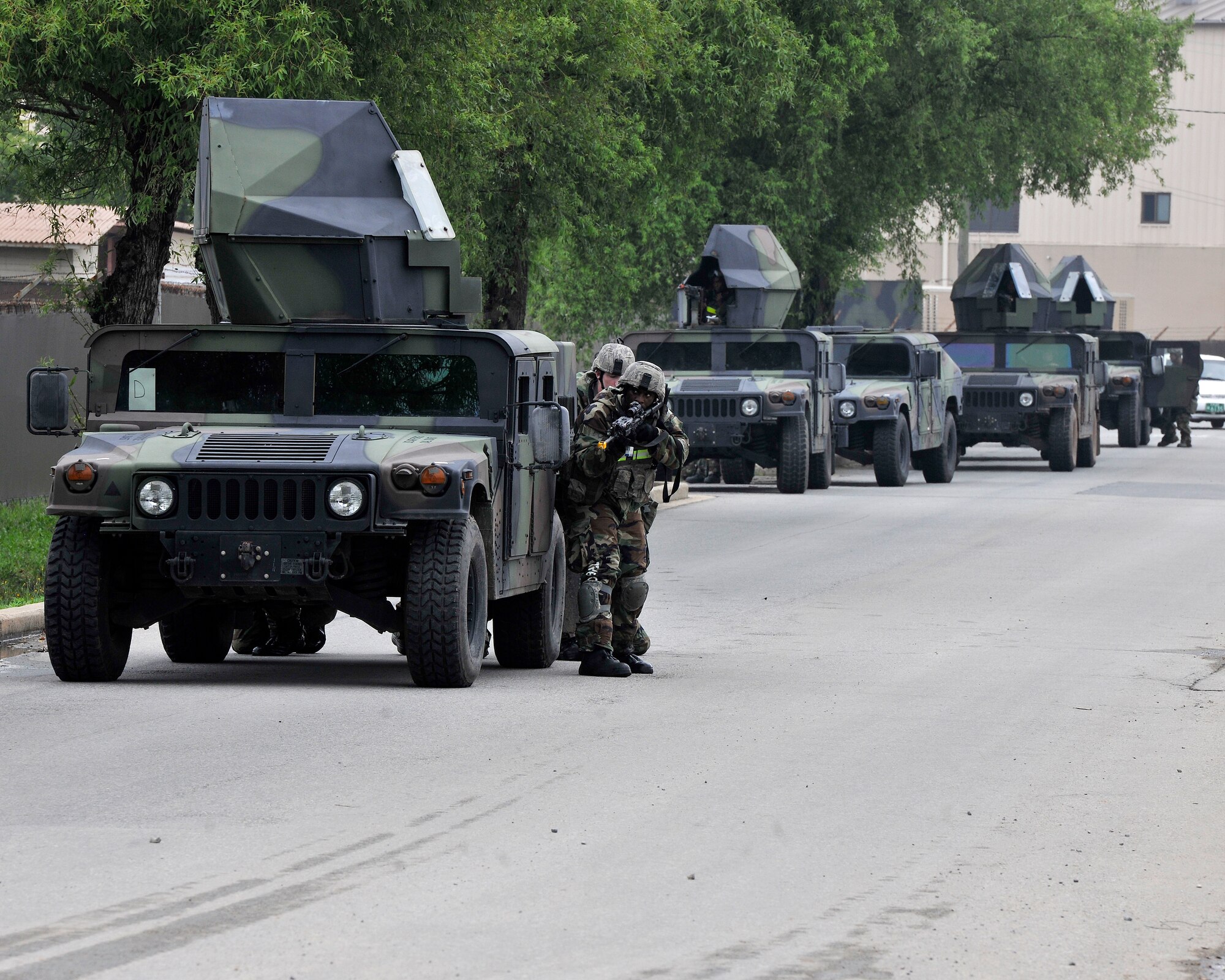 Members of the 8th Security Forces Squadron take cover behind a Humvee during exercise Beverly Midnight 12-03 on Kunsan Air Base, Republic of Korea, July 11, 2012. They were responding to a simulated ground attack by hostile forces designed to test their ability to quickly and effectively respond. (U.S. Air Force photo/Staff Sgt. Jonathan Fowler)