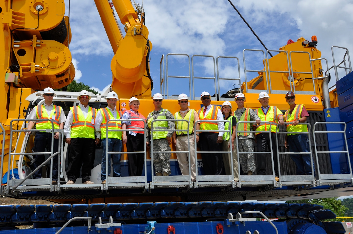 LANCASTER, Tenn. — U.S. Army Corps of Engineers Nashville District and Bauer Foundation Corporation management and personnel pose for photos on a specialty drill rig July 11, 2012 during a "First Bite" ceremony to begin constructing a subsurface concrete wall as a barrier for potentially harmful seepage water moving beneath the earthen dam.
