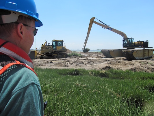 NEW YORK — Project Stakeholder from the New York State Department of Environmental Conservation watches hummock removal process on Yellow Bar Hassock marsh island. 