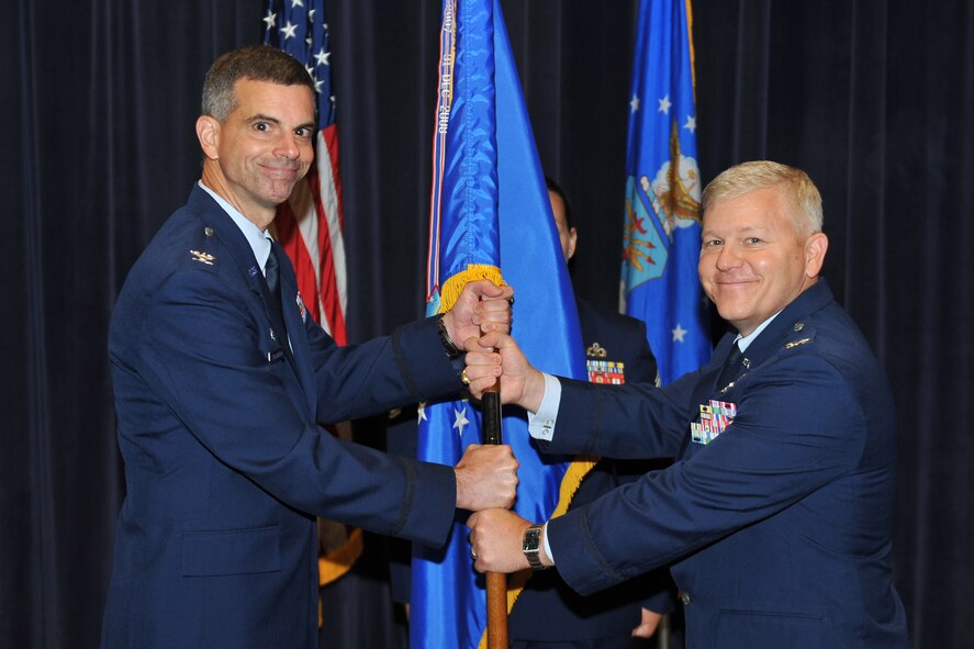 OFFUTT AIR FORCE BASE, Neb. -- Col. Louis Zuccarello, Air Force Weather Agency commander, hands the 2d Weather Group guidon to Col. David Bacot, signifying the official change of command for the group during a ceremony at AFWA's Chief Master Sgt. Peter Morris Auditorium July 12. Bacot, who comes to the 2d WXG from Fort McNair in Washington D.C., assumed command from Col. Steven DeSordi, who now leaves for the Pentagon. (Air Force photo by Jeff Gates)
