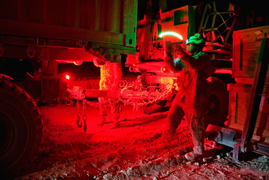 U.S. Army Staff Sgt. Vincent Watkins, left, directs a truck backing to a trailer on Forward Operating Base Arian in Afghanistan's Ghazni province, July 8, 2012. Watkins, a logistics non-commissioned officer, is assigned to the 82nd Airborne Division's 307th Brigade Support Battalion, 1st Brigade Combat Team.
