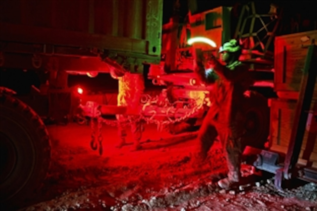 U.S. Army Staff Sgt. Vincent Watkins, left, directs a truck backing to a trailer on Forward Operating Base Arian in Afghanistan's Ghazni province, July 8, 2012. Watkins, a logistics non-commissioned officer, is assigned to the 82nd Airborne Division's 307th Brigade Support Battalion, 1st Brigade Combat Team.