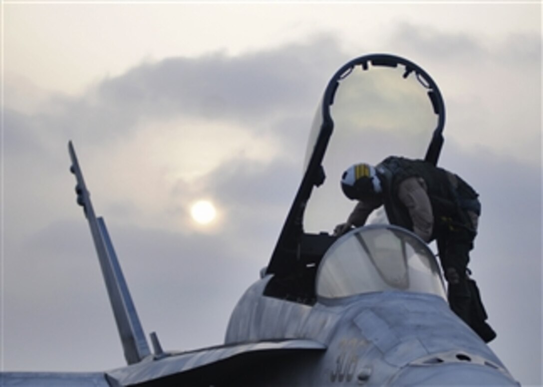 A U.S. Navy pilot exits an F/A-18C Hornet aircraft after landing aboard the aircraft carrier USS Abraham Lincoln in the Arabian Sea on July 9, 2012. The pilot and Hornet are attached to Strike Fighter Squadron 151.  