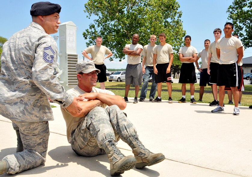 Senior Master Sgt. James McGarvey, 512th Security Forces member and Development and Training Flight coordinator, instructs D&TF recruits on proper sit-up position during the June event at Dover Air Force Base, Del., June 23, 2012. Some members will only experience one D&FT assembly, while others will participate in multiple weekends up to one year, based on their projected BMT departure date. (U.S. Air Force photo by Staff Sgt. Andria J. Allmond)