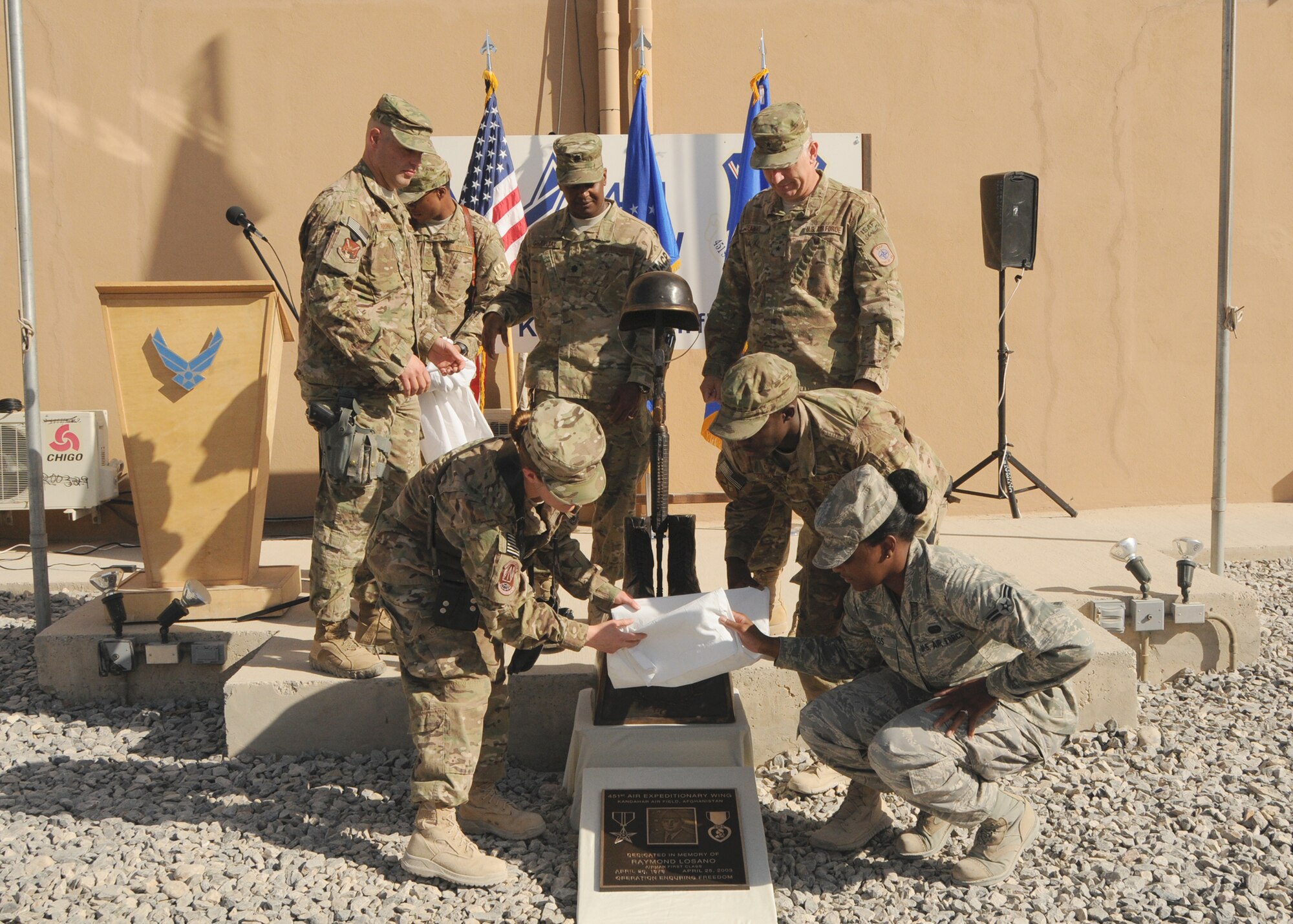 First Four Airmen, Command Chief Master Sgt. David Brinkley, Lt. Col. Eric Chapital, 504 Expeditionary Air  Support Operations Group Deputy Commander, and Brig. Gen. Scott L. Dennis, 451st Air Expeditionary Wing and Kandahar Airfield Commander, unveil the newly dedicated memorial for Airman 1st Class Raymond Losano in Camp Losano, Kandahar Airfield, Afghanistan, June 29. (U.S. Air Force photo/Staff Sgt. Heather Skinkle)
