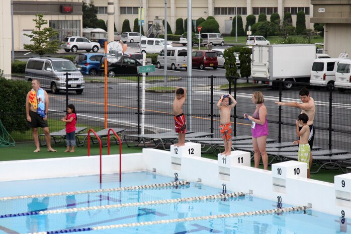Participants in the Marine Corps Community Services nine and younger age group of the Splash-and-Dash race stand by at the starting line at::r::::n::the WaterWorks pool here as their parents instruct them July 14, 2012. The Children in the nine and younger age group swam the length of the::r::::n::50 meter pool.