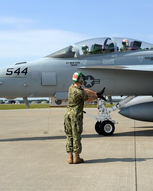 Aviation Structural Mechanic 3rd Class Paul White, an Electronic Attack Squadron (VAQ) 132 crew member, who originally hails from New Baltimore, Mich., directs an EA-18G Growler as it taxis down the ramp at Naval Air Facility Misawa, Japan, July 14, 2012.  VAQ-132 is beginning a six-month deployment on board NAF Misawa and will operate largely from this northern Japan-located U.S. naval installation.  (U.S. Navy photo by Senior Chief Mass Communication Specialist Daniel Sanford/Released)